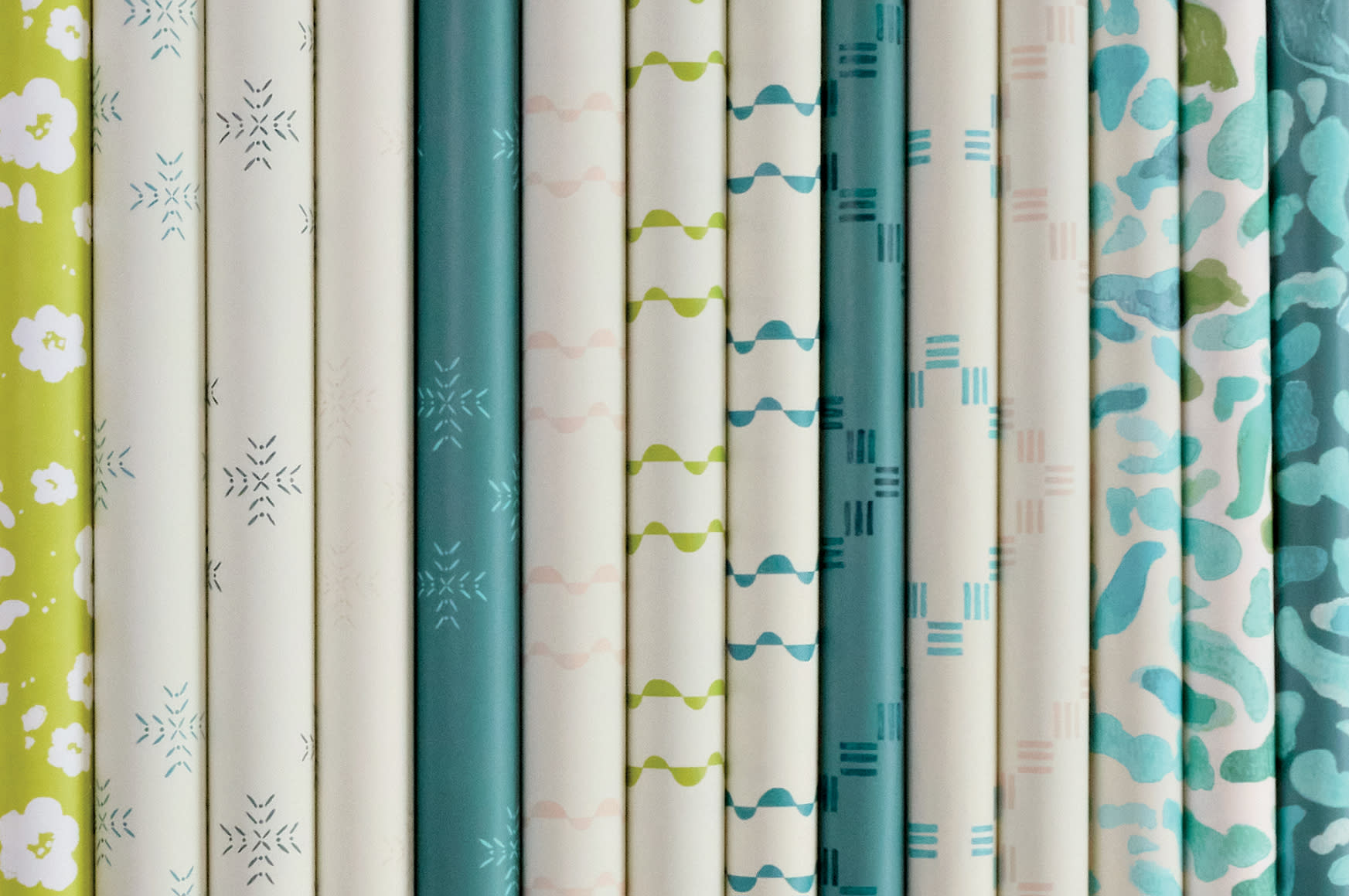 collection of blue, white and green rolls of wallpaper