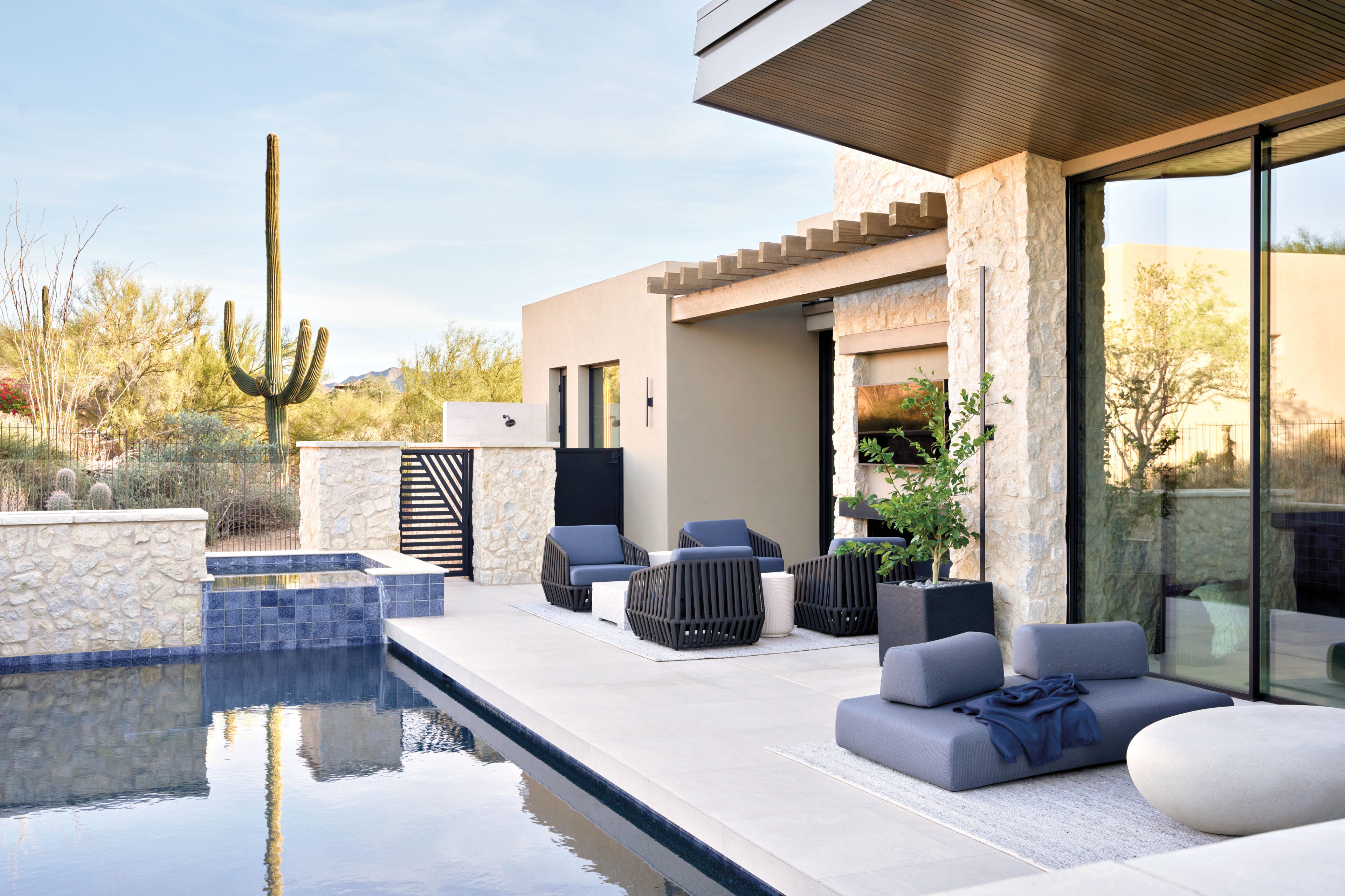 exterior of a stone home with a pool in the desert