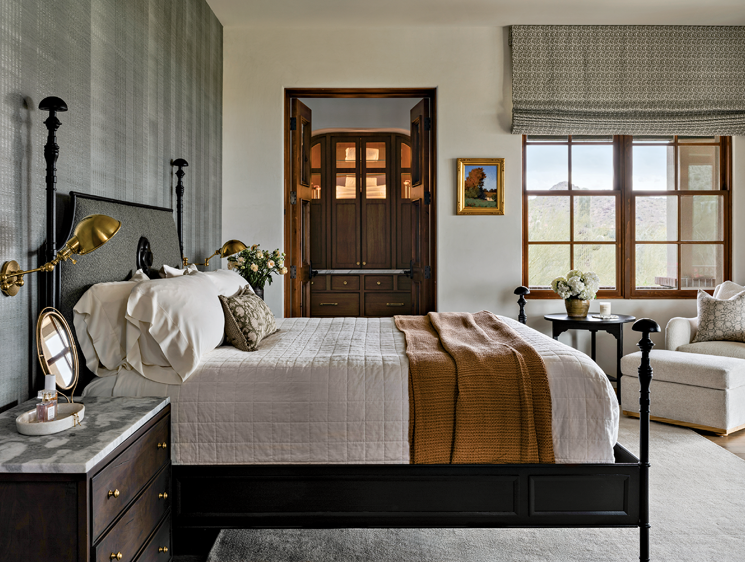 Elegant bedroom with a cozy bed featuring white linens and a brown throw blanket.