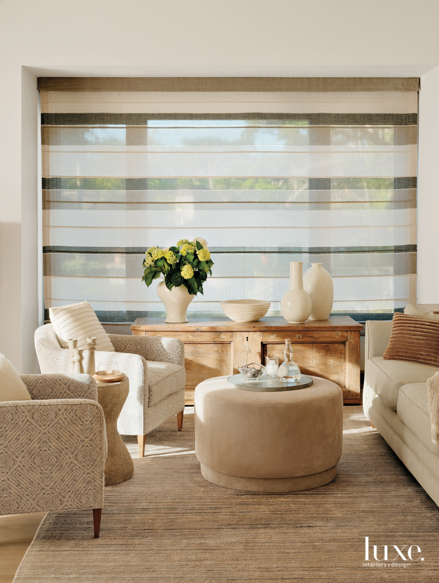 A sitting area in the guest bedroom is done in neutral tones.