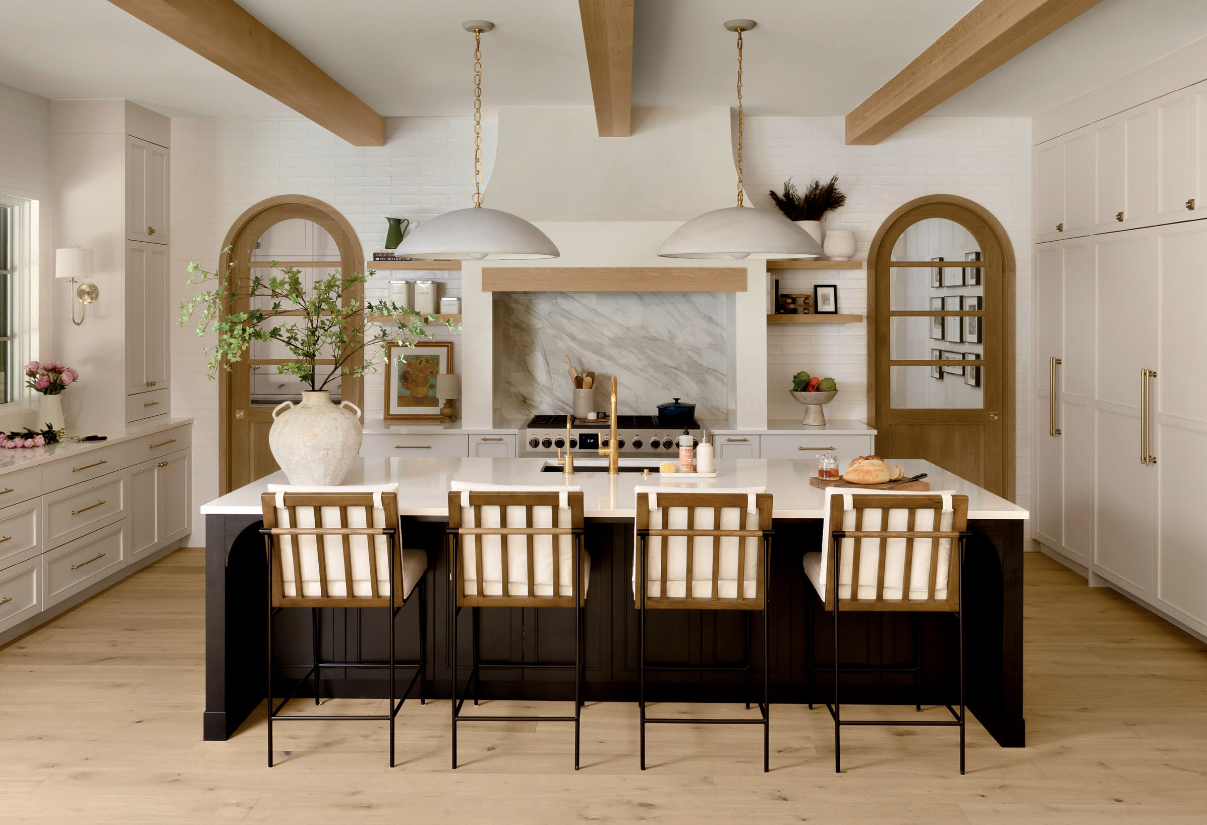 classic meets contemporary kitchen with a dark-stained island and arched doorways