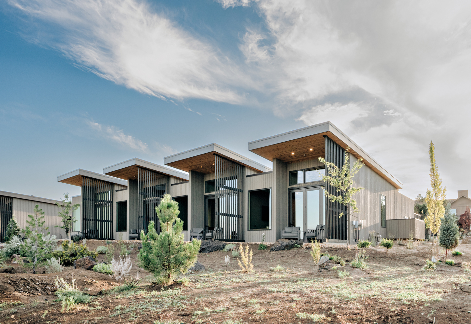 Exterior of rectangular bungalows with flat roofs and floor-to-ceiling windows