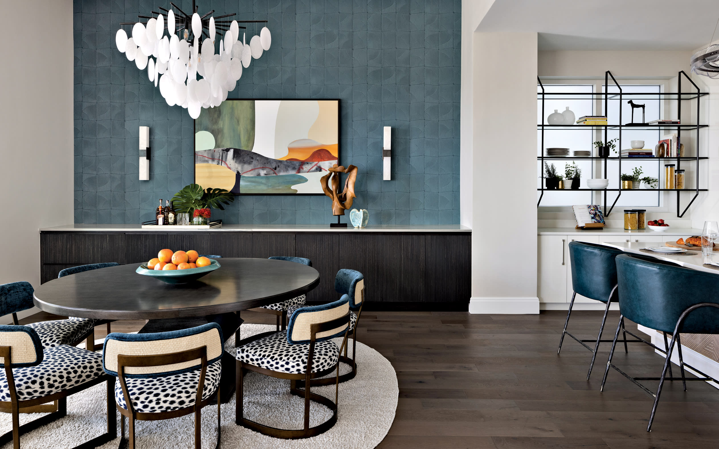 modern dining area with a blue wallpaper along one wall and cow-print dining chairs