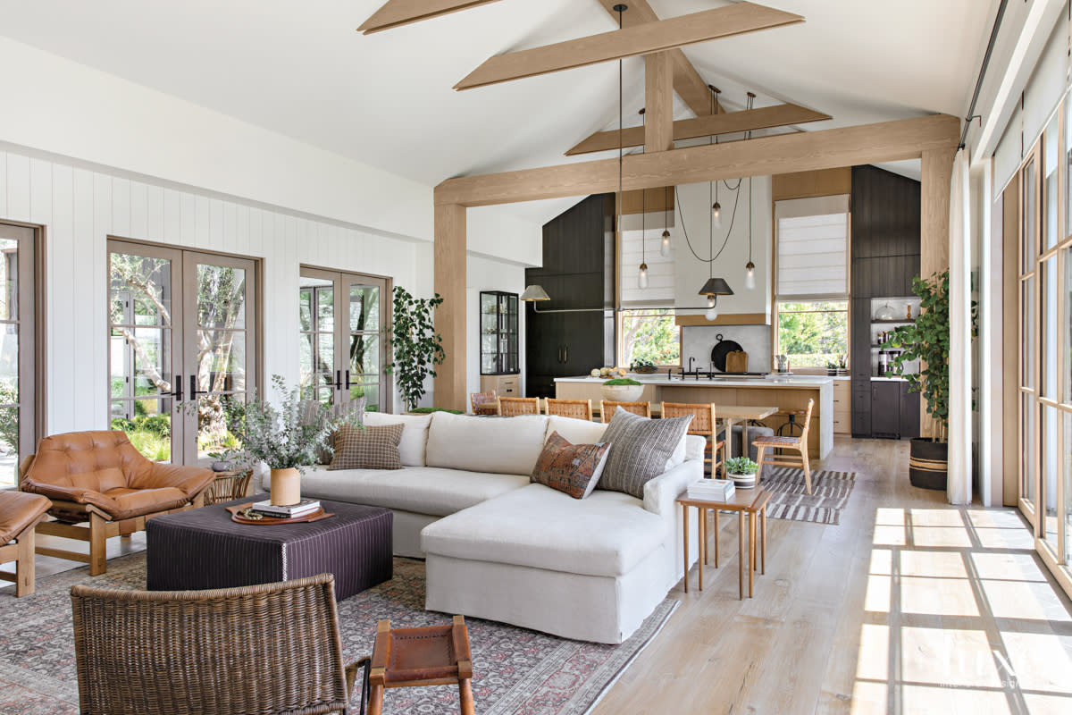 the great room with wood beams, window doors and a sectional