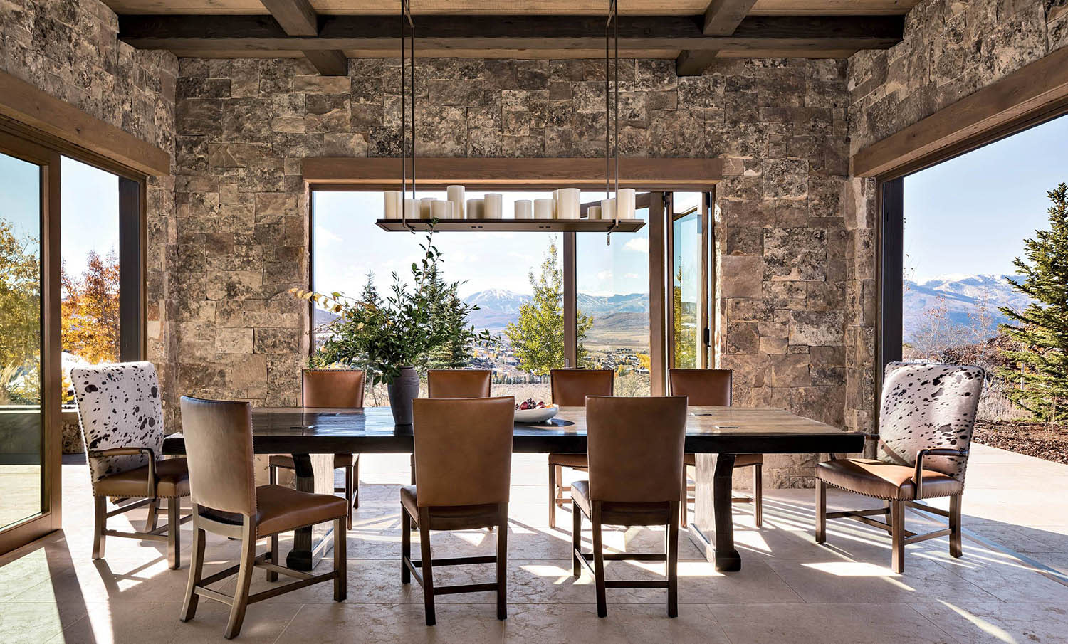dining room with stone walls and large windows showcasing mountain views