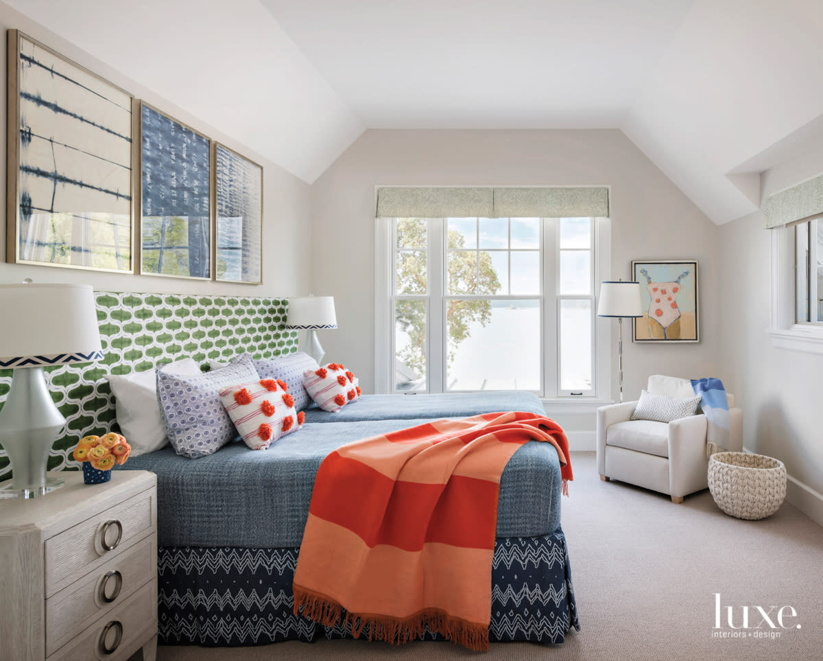 Guest bedroom with green patterned headboard and views to water.