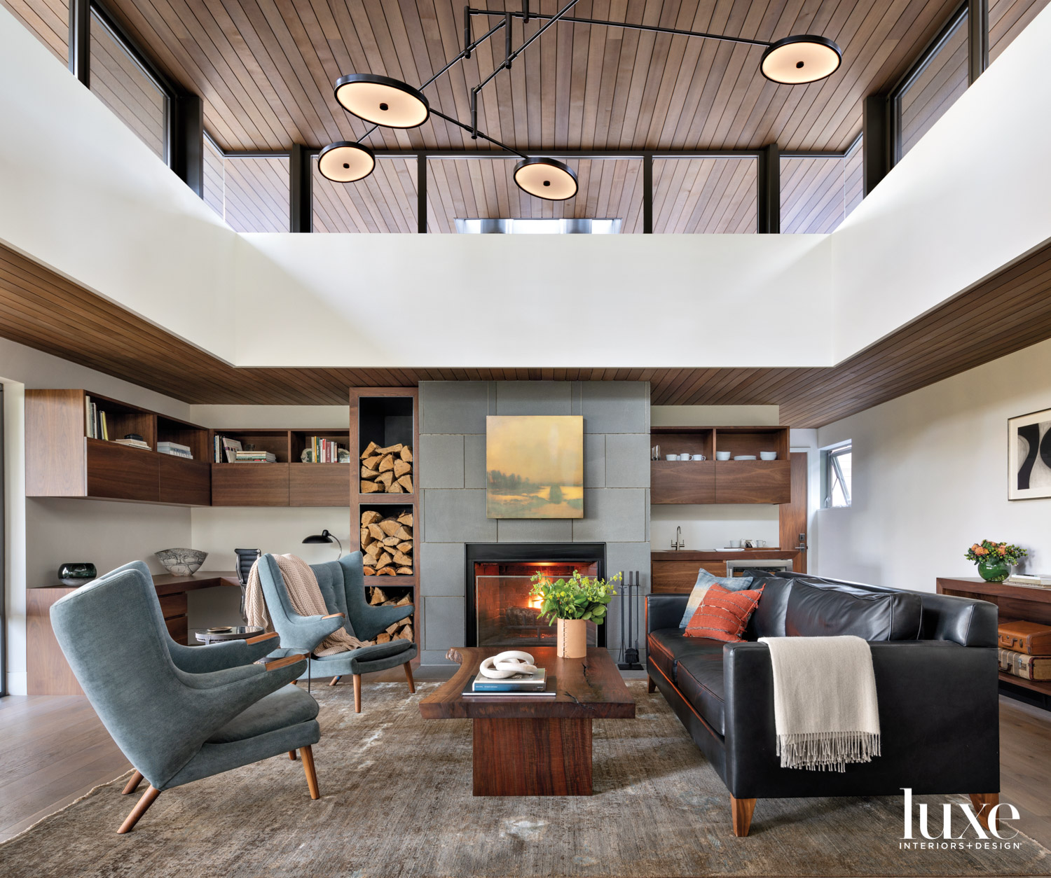 Office with clerestory above, pair of lounge chairs, coffee table and black leather couch