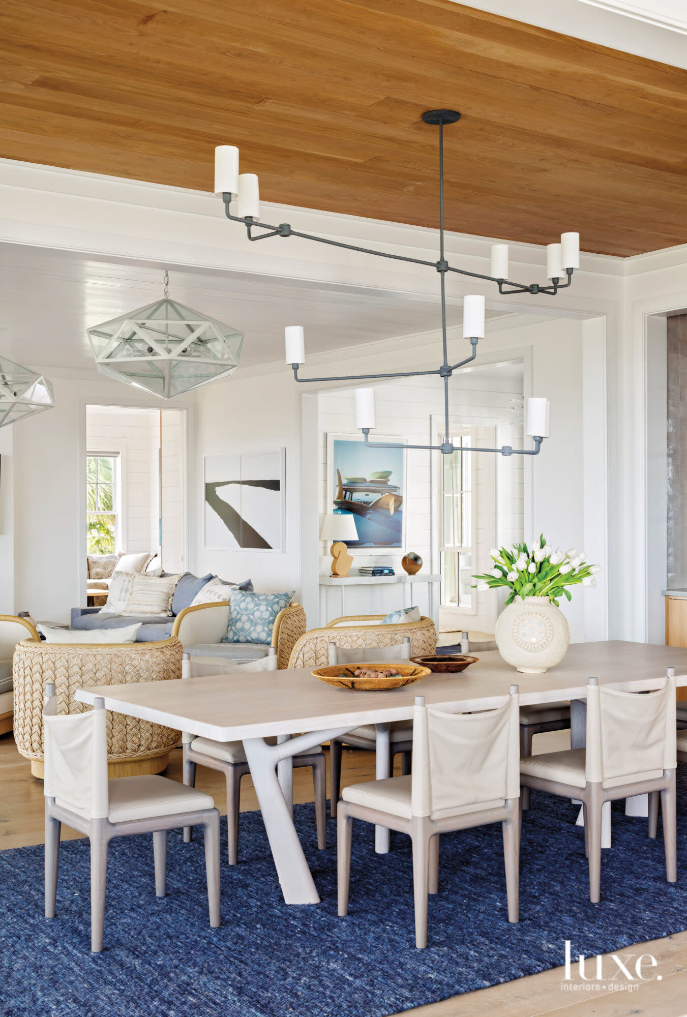 Dining area featuring large chandelier and wood ceiling, located adjacent to living space