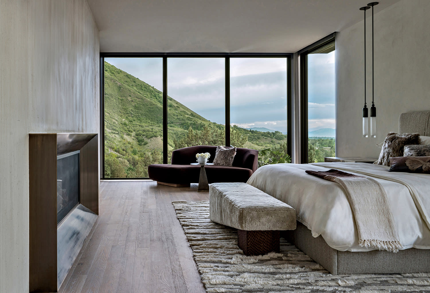 brass-framed inset fireplace in a contemporary mountain home bedroom