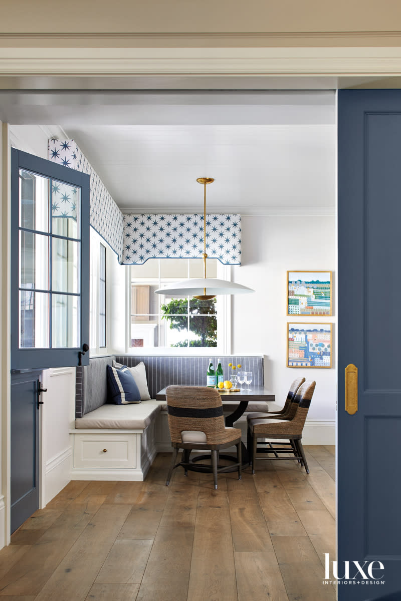 A blue-and-white striped banquette in the corner of a kitchen.