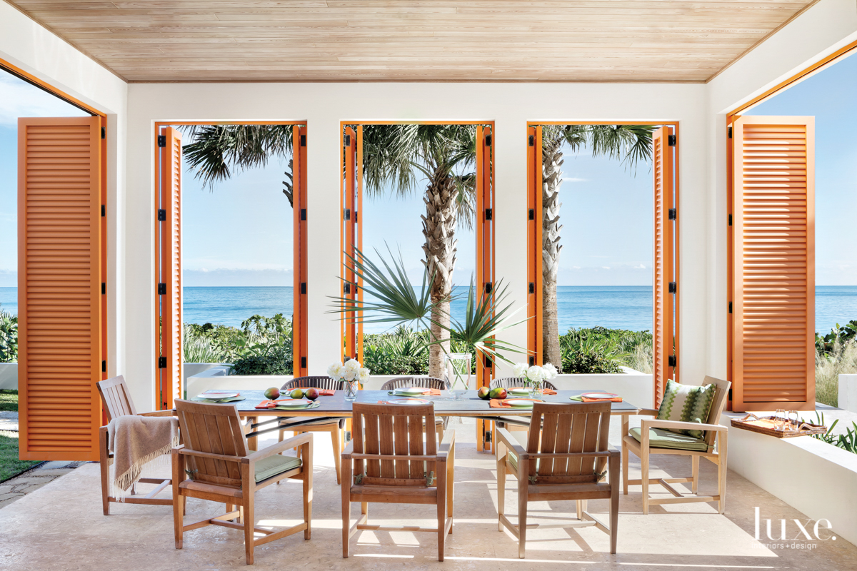 cabana with orange shutters and janus et cie chairs in home by Peter Moor