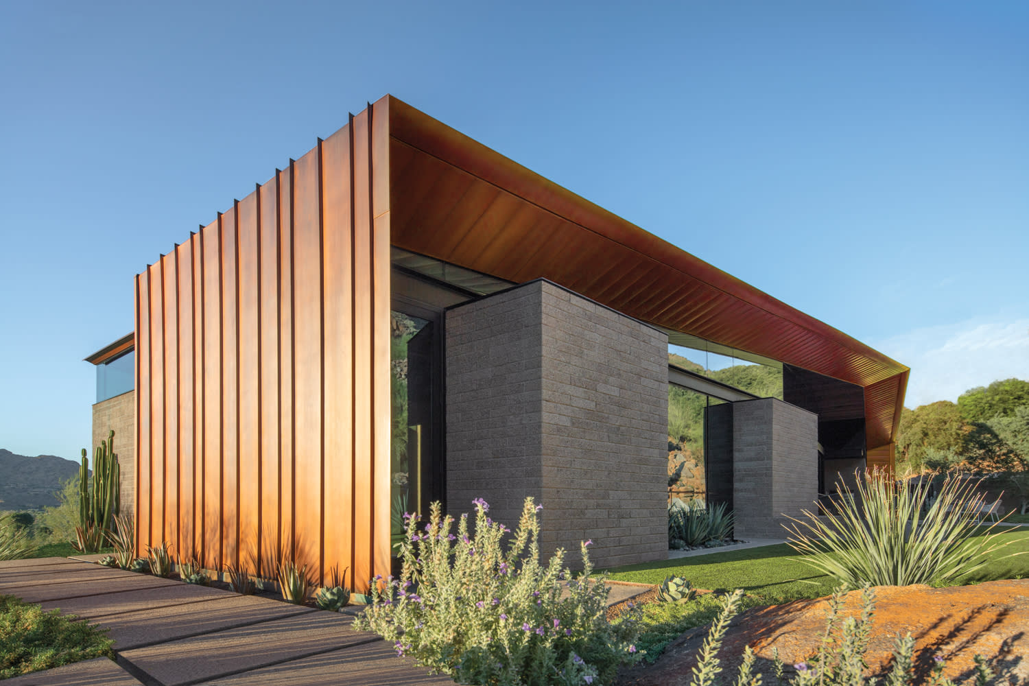 Exterior contemporary desert home with a copper overhanging roof and concrete-block walls