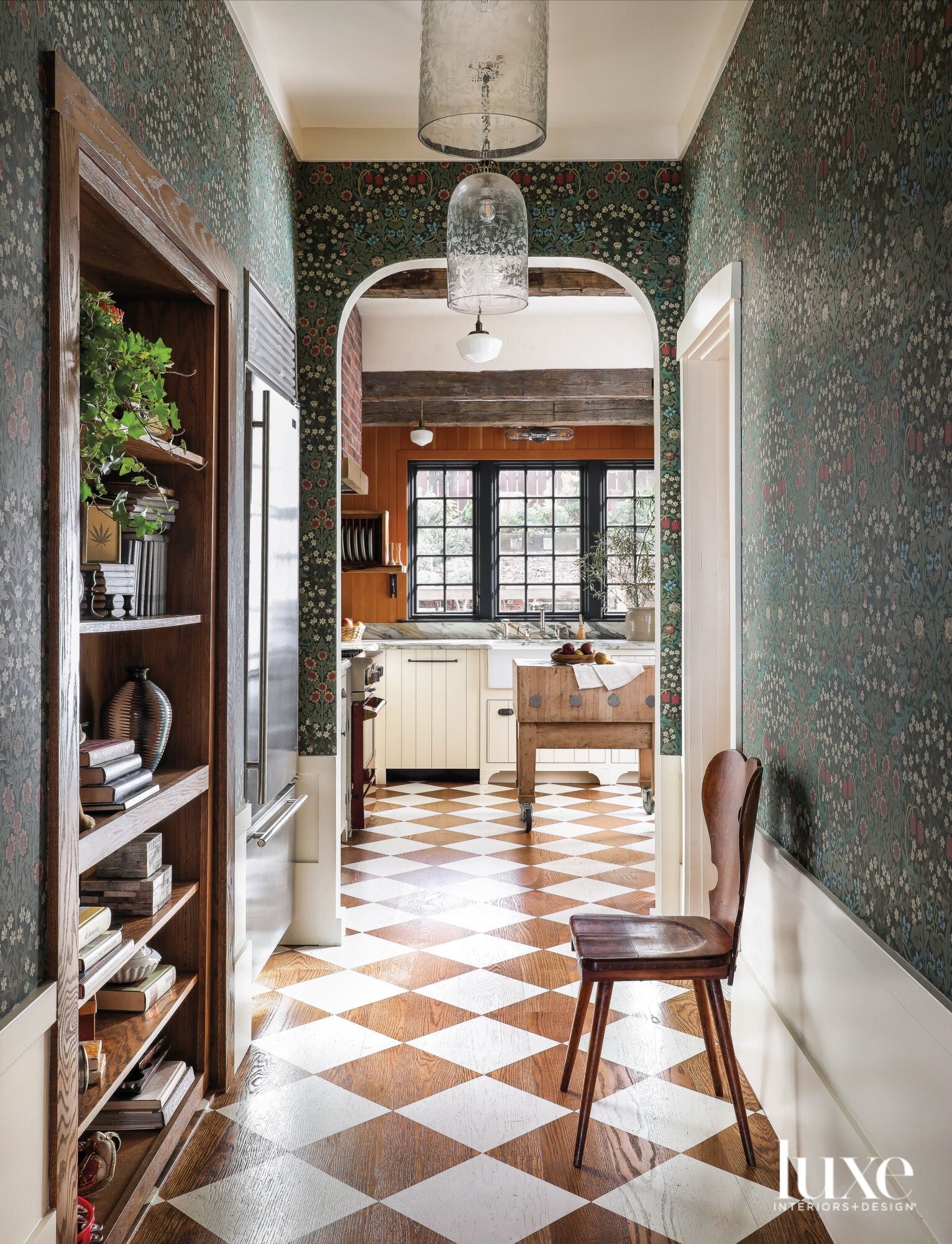 A hallway leading into a kitchen has a checkerboard pattern on the floor.