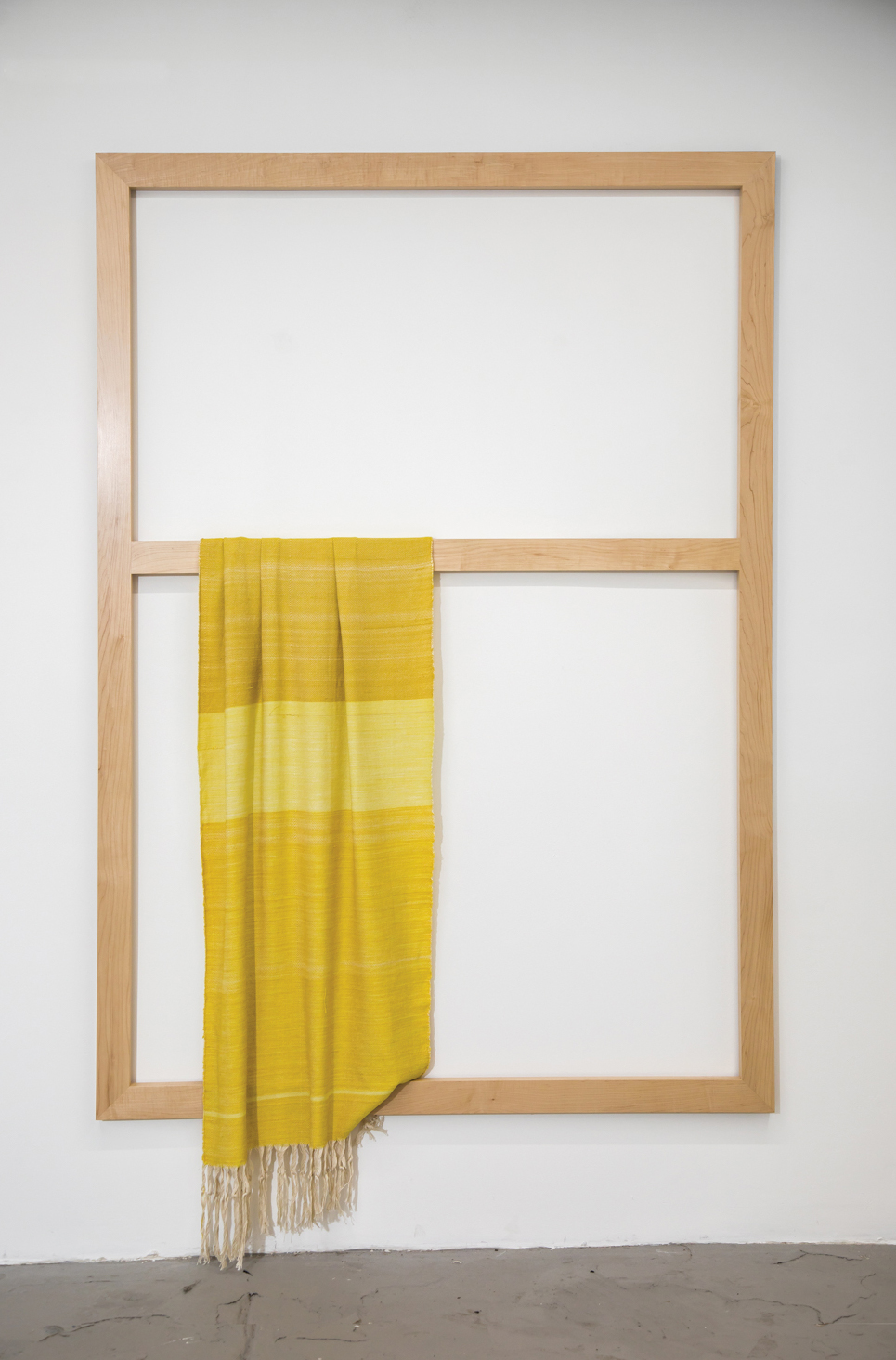 yellow cloth draped off-center on a wood frame