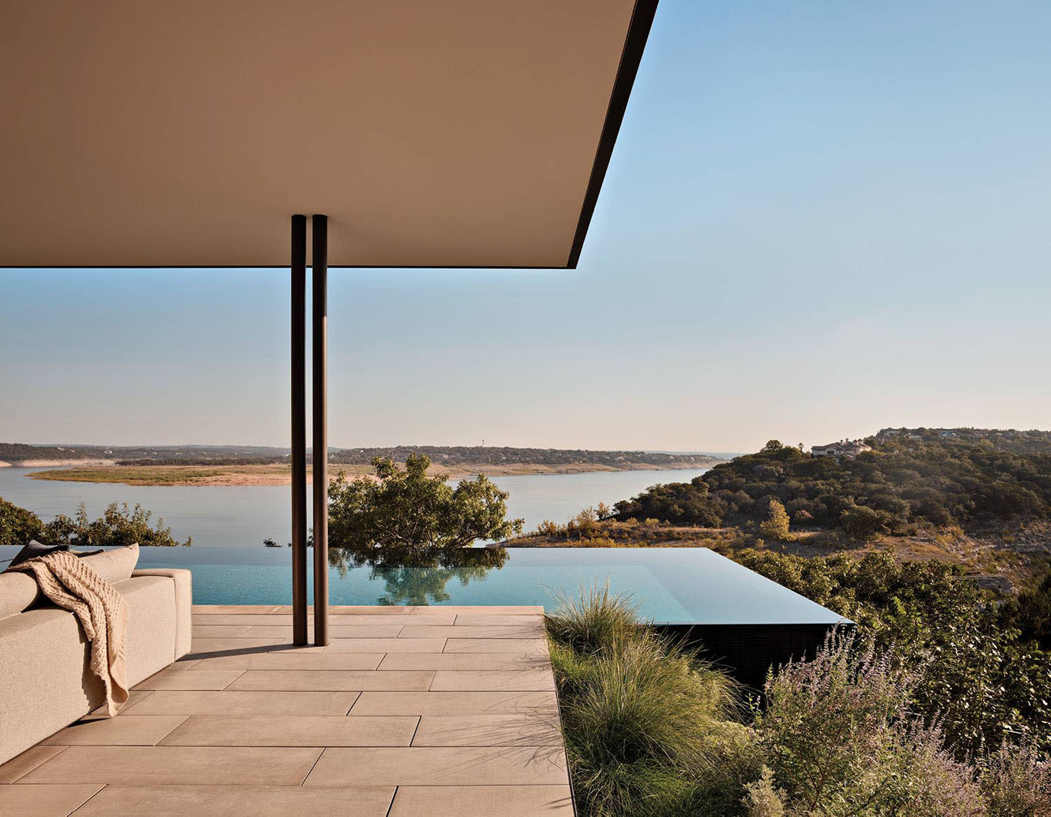 outdoor lounge next to an infinity pool overlooking Lake Travis, Texas