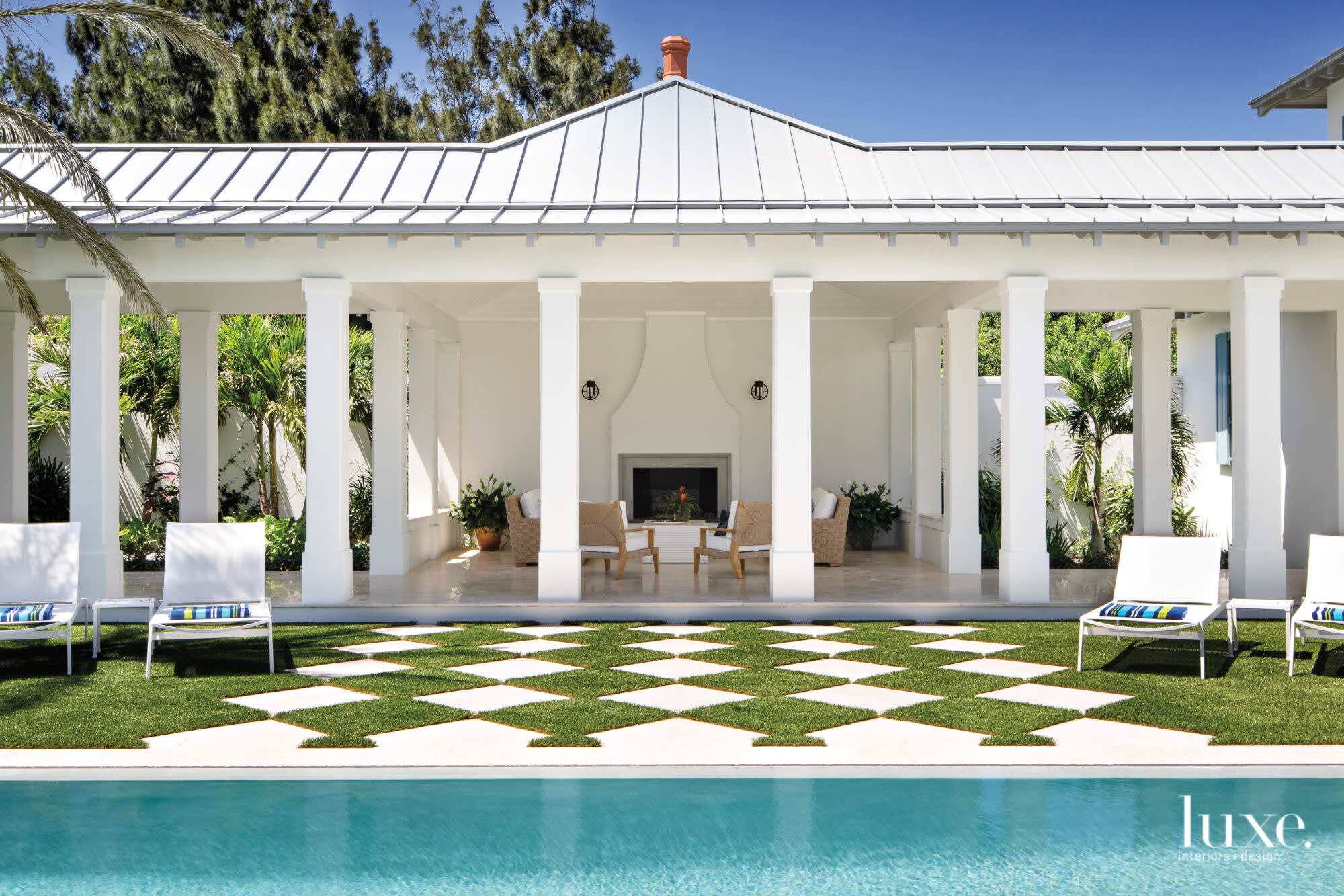 Pool courtyard with covered loggia and checkerboard of turf and hardscape.