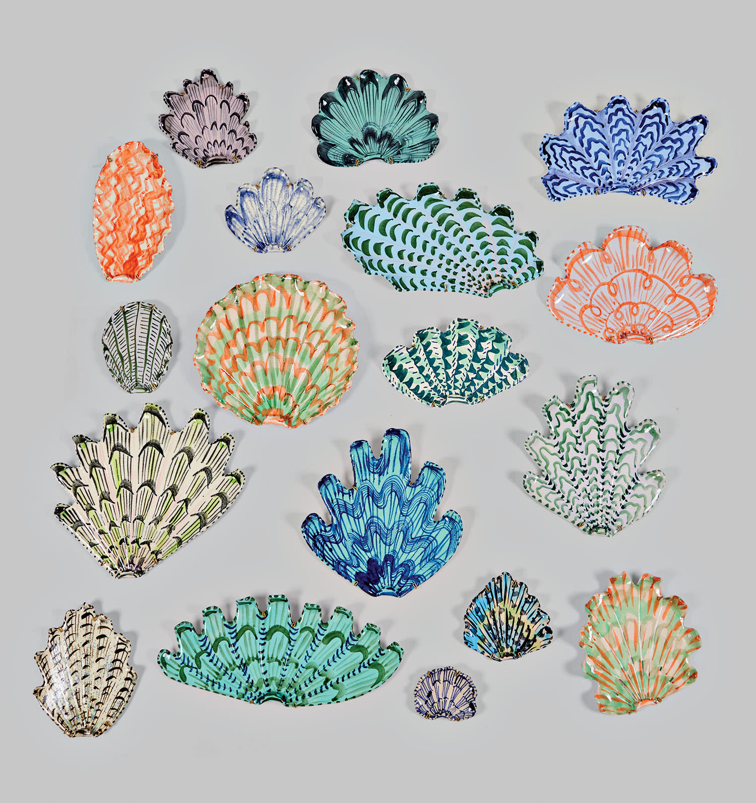 A collection of colorful patterned ceramic shells on a white background.