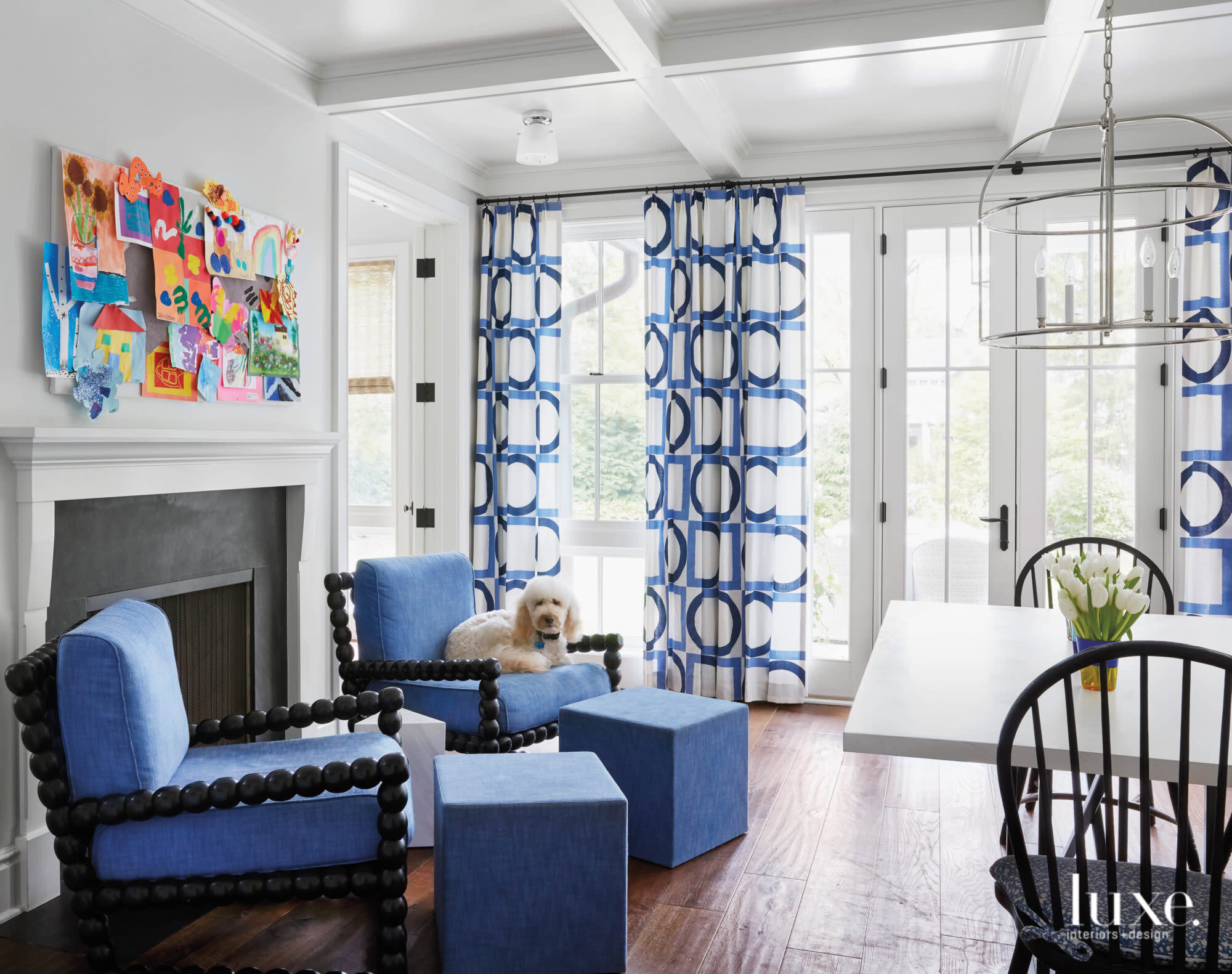 blue chairs near fireplace with children's artwork