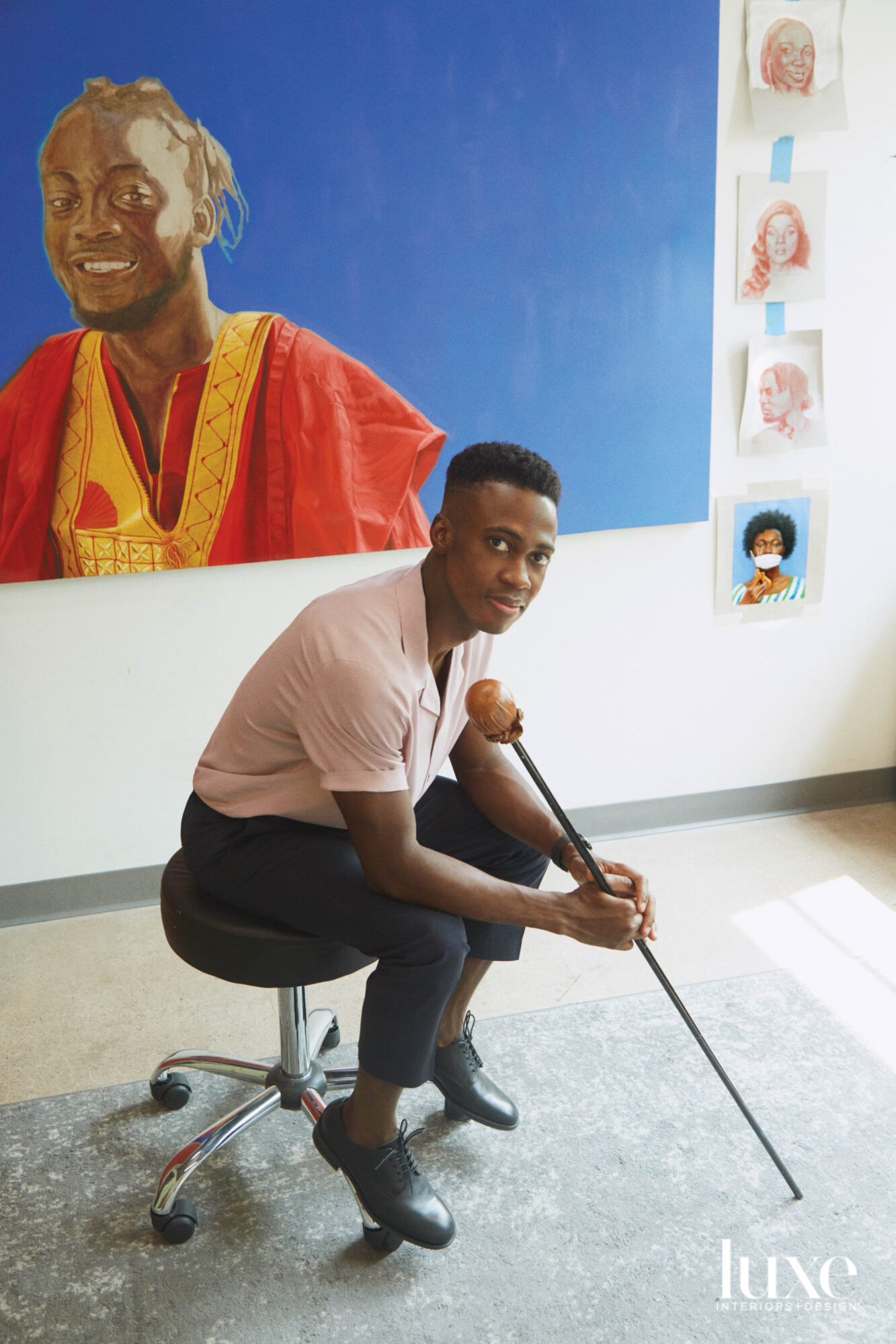 Artist Papay Solomon in front of a portrait.