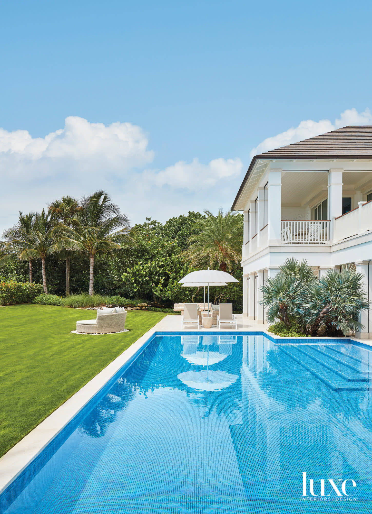 Backyard with chaises overlooking a pool.