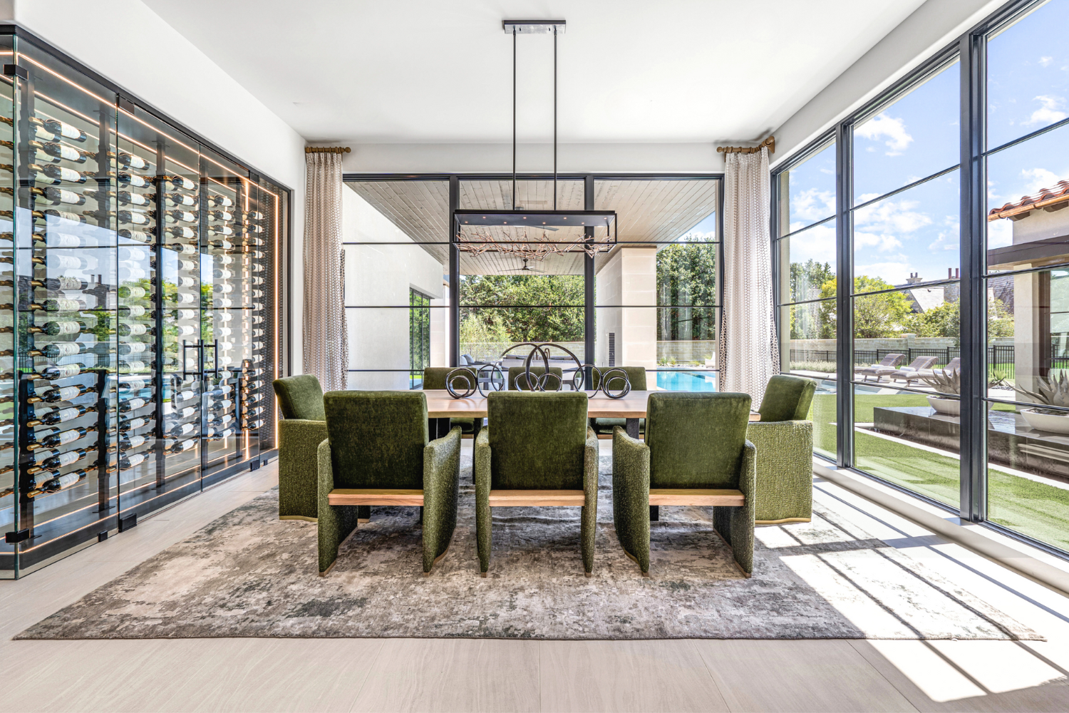 Modern Mediterranean, Fort Worth: This elegant dining room by Susan Semmelmann Interiors features a wine cellar behind stylish glass doors, inviting warmth and sophistication to the space.