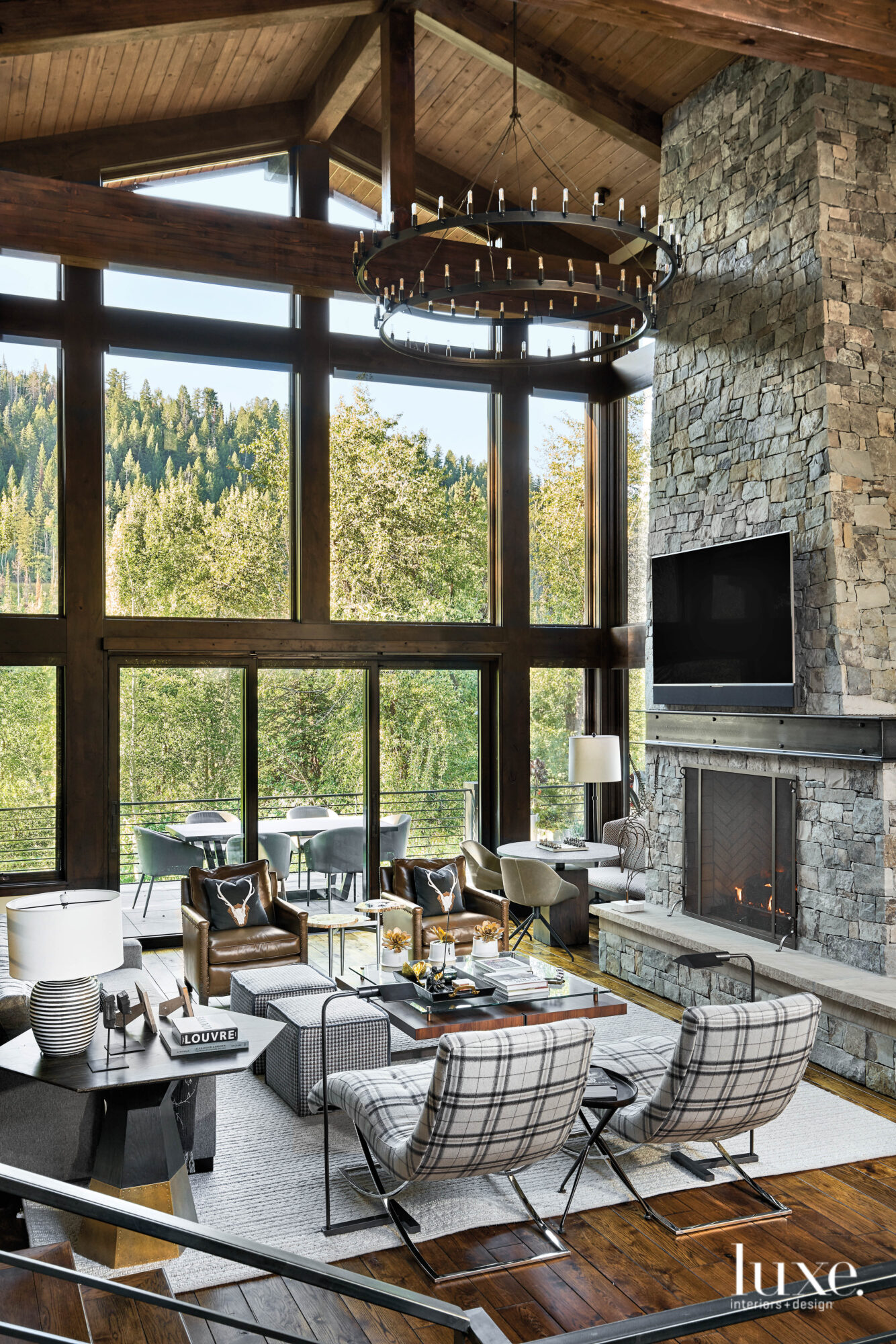 The living room has seating area set against floor-to-ceiling windows.