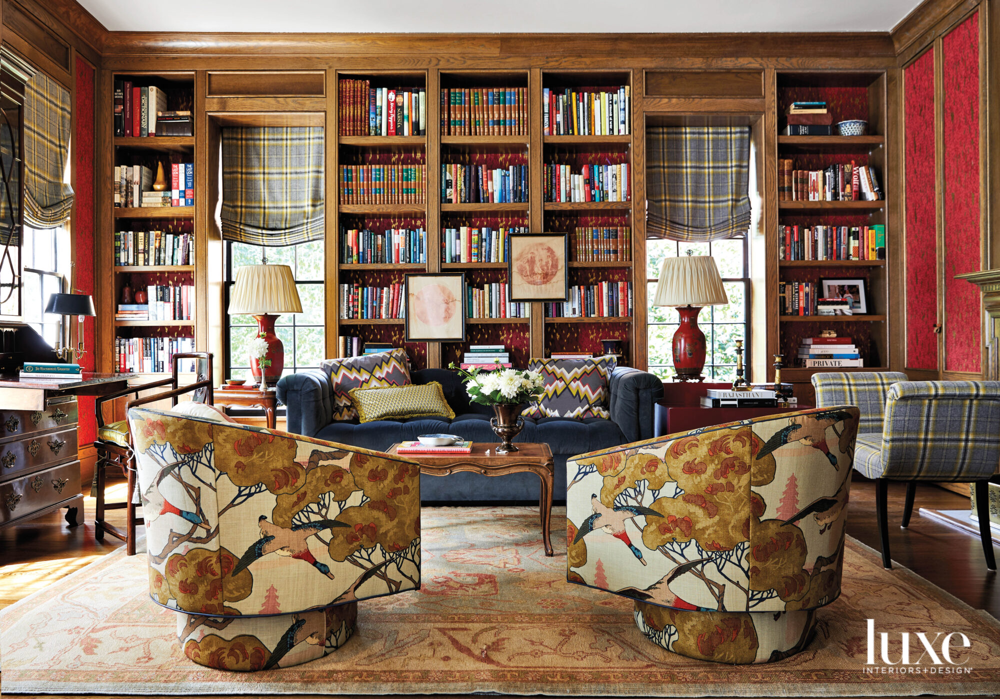 Wood-paneled library with books, swivel armchairs and Chesterfield sofa