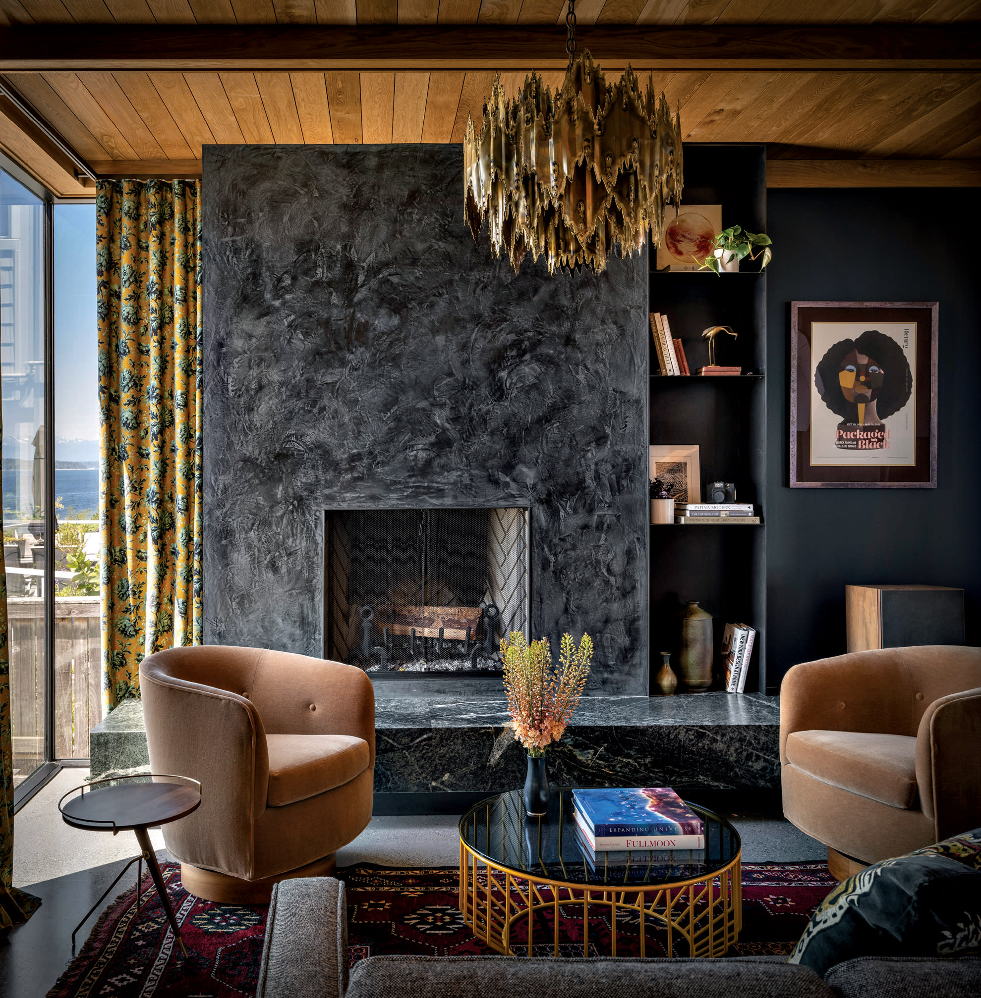 dark and moody living room with black and gray marble fireplace and a Brutalist light fixture