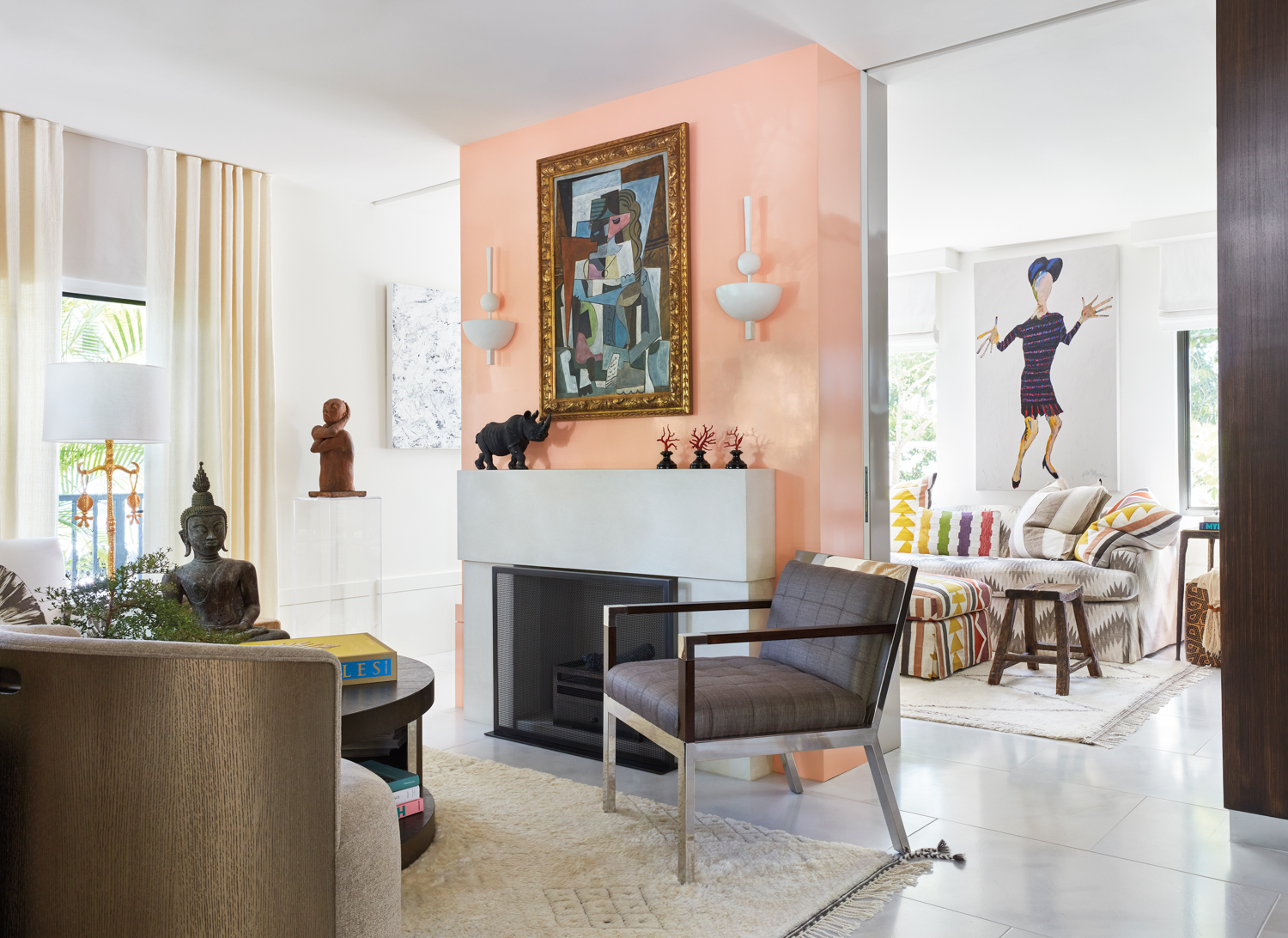 living area with peach-colored fireplace, white walls, armchair and artwork