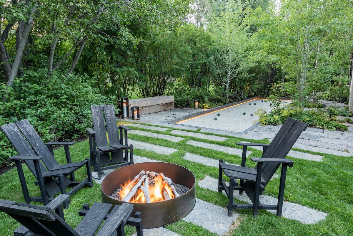 A cozy backyard with a fire pit surrounded by chairs, perfect for gathering and enjoying outdoor evenings.