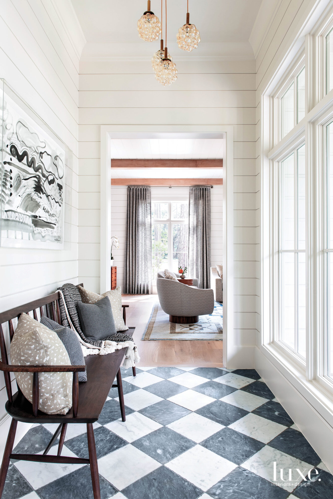 Window-lit hallway with Windsor bench, shiplap walls and checkerboard floors