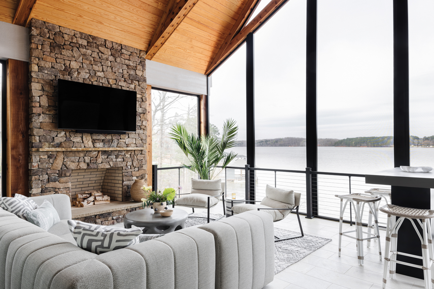 Covered porch with tumbled stone fireplace, modern outdoor upholstery and serene views of Lake Tillery