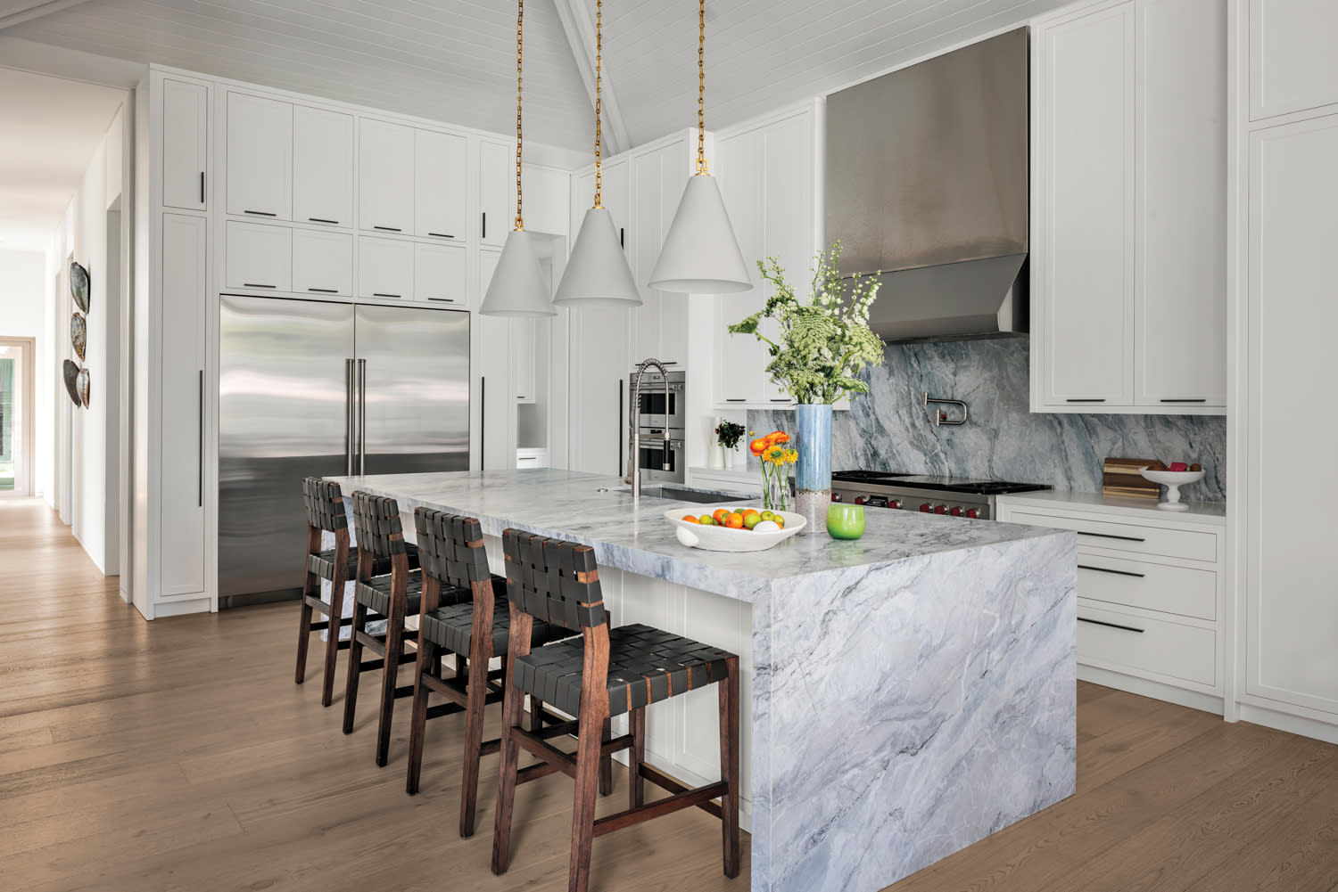 modern kitchen with a natural quartzite waterfall island and stainless steel appliances