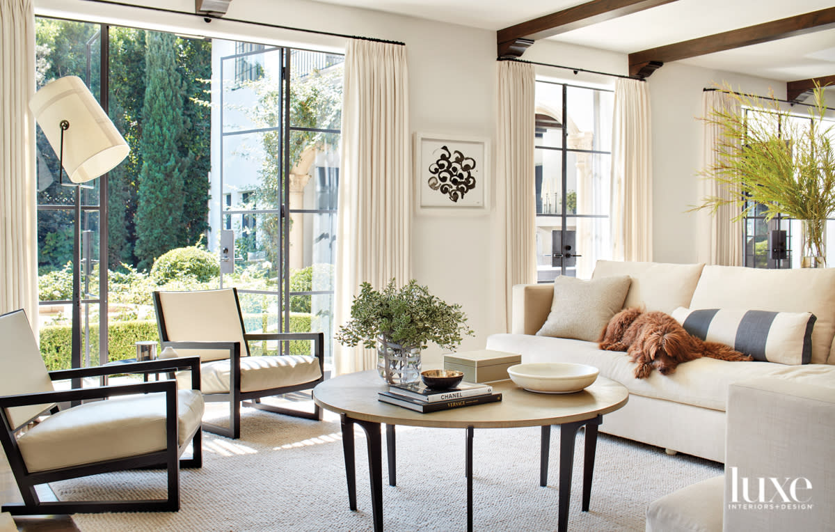 Family room with two chairs and a dog sitting on a sofa