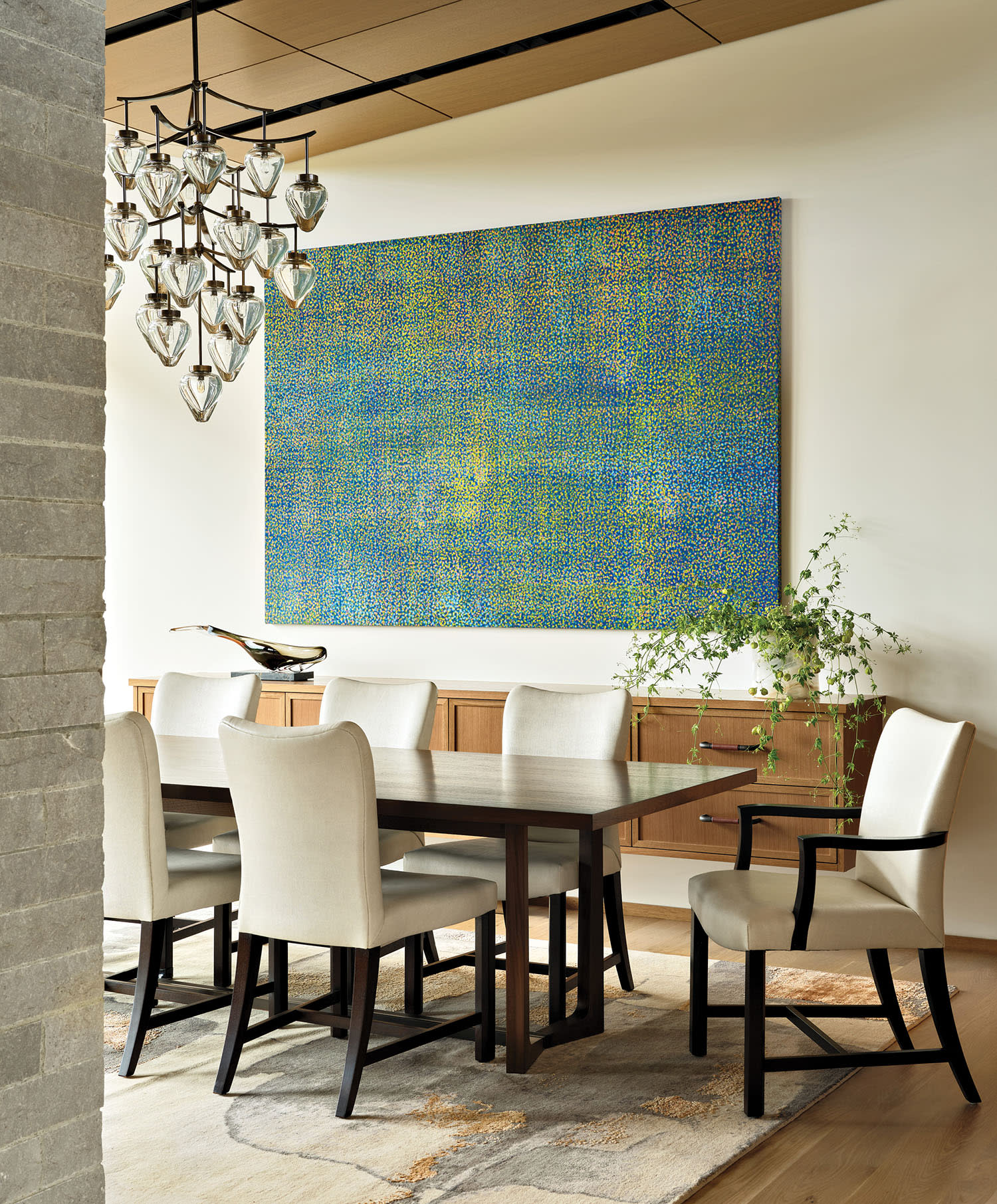 dining room with a floating white oak buffet and a glass chandelier