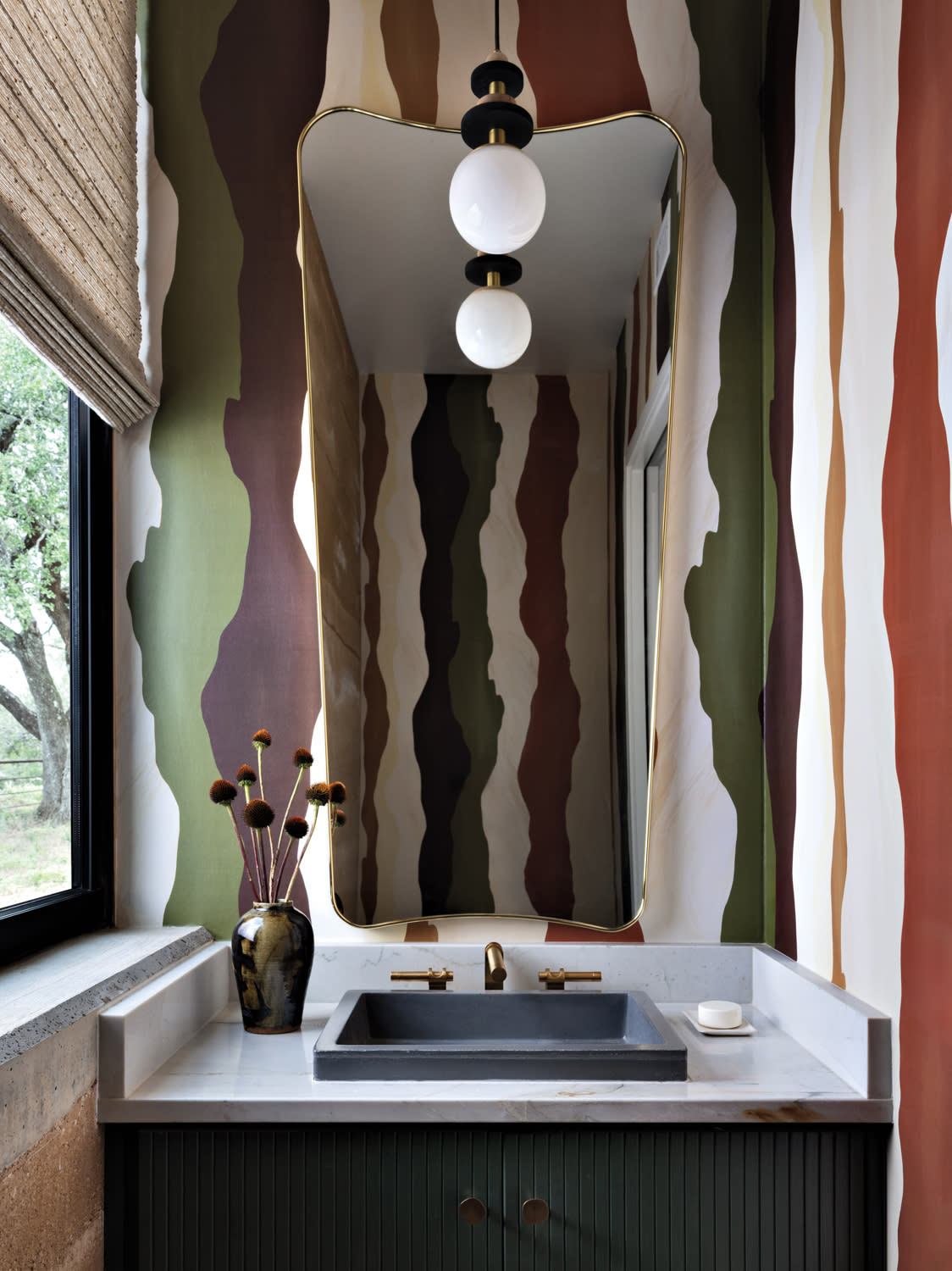organic stripes in reds, greens, and whites line the wall of this powder room