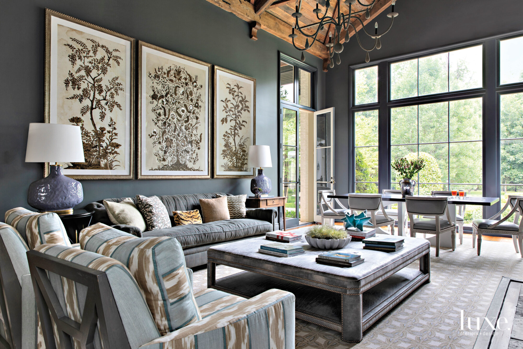 Modern organic family room with dark gray walls, florid artwork, wood ceiling, big windows 