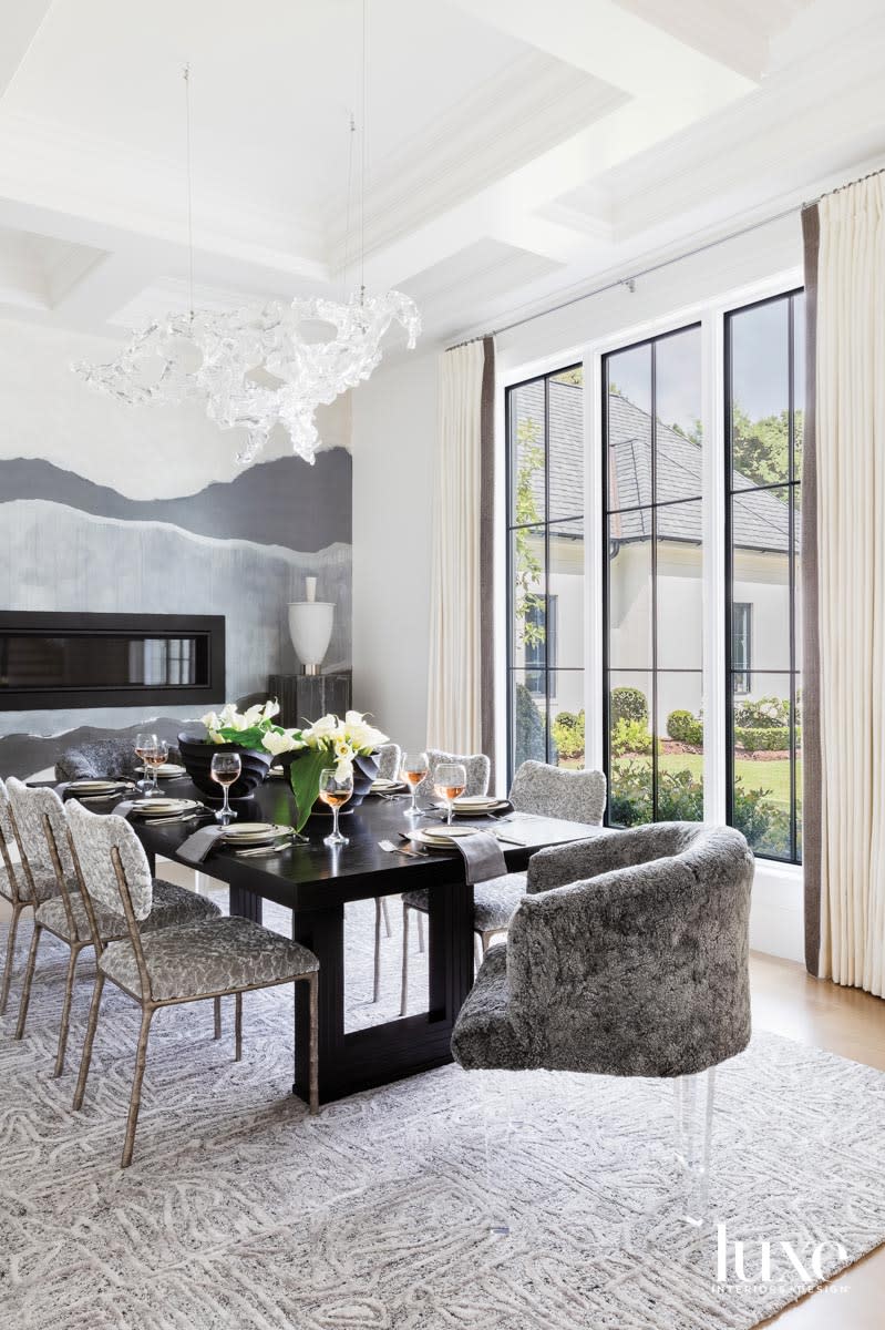 Dining room with large windows, fluffy dining chairs and abstract gray wall mural