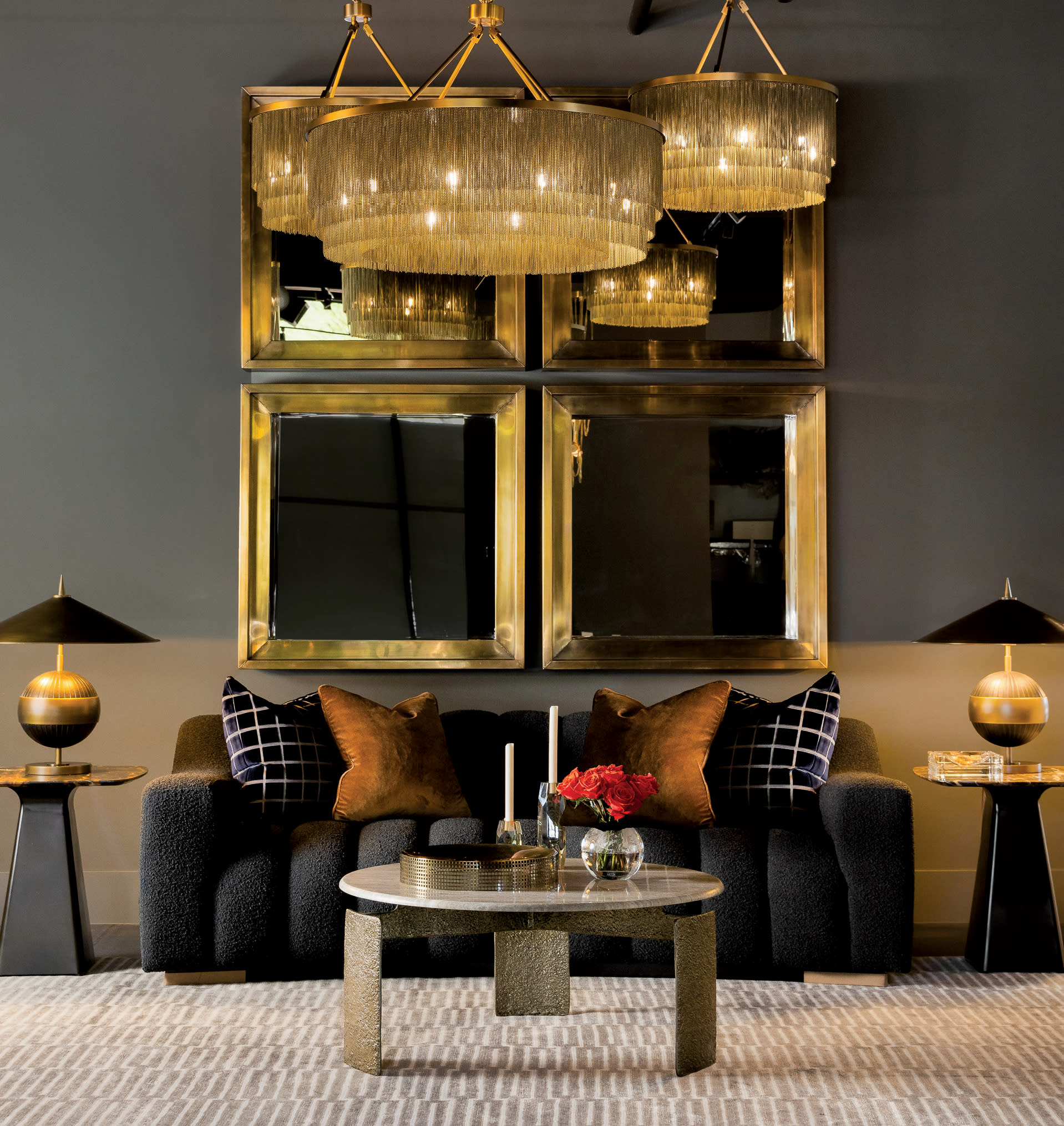 sparkly chandeliers hang above a cozy black couch at Arbor Row