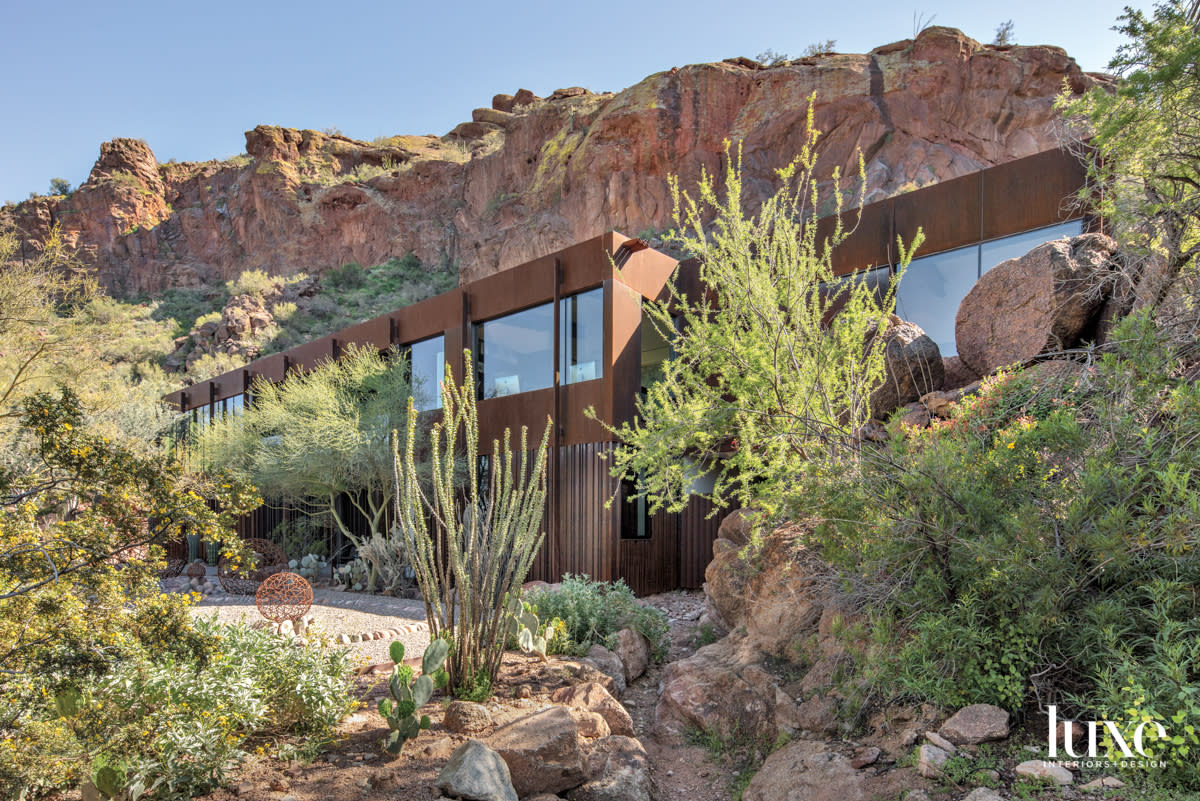 A steel house is built into the side of mountain.