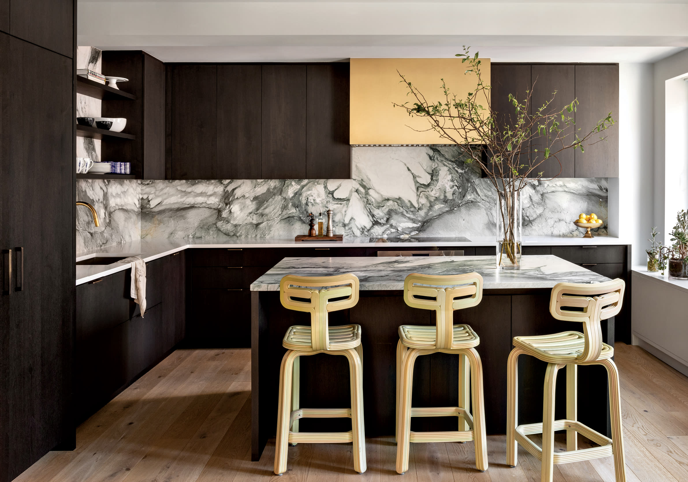 kitchen with dark wood cabinetry, white oak flooring and a grey and white stone backsplash