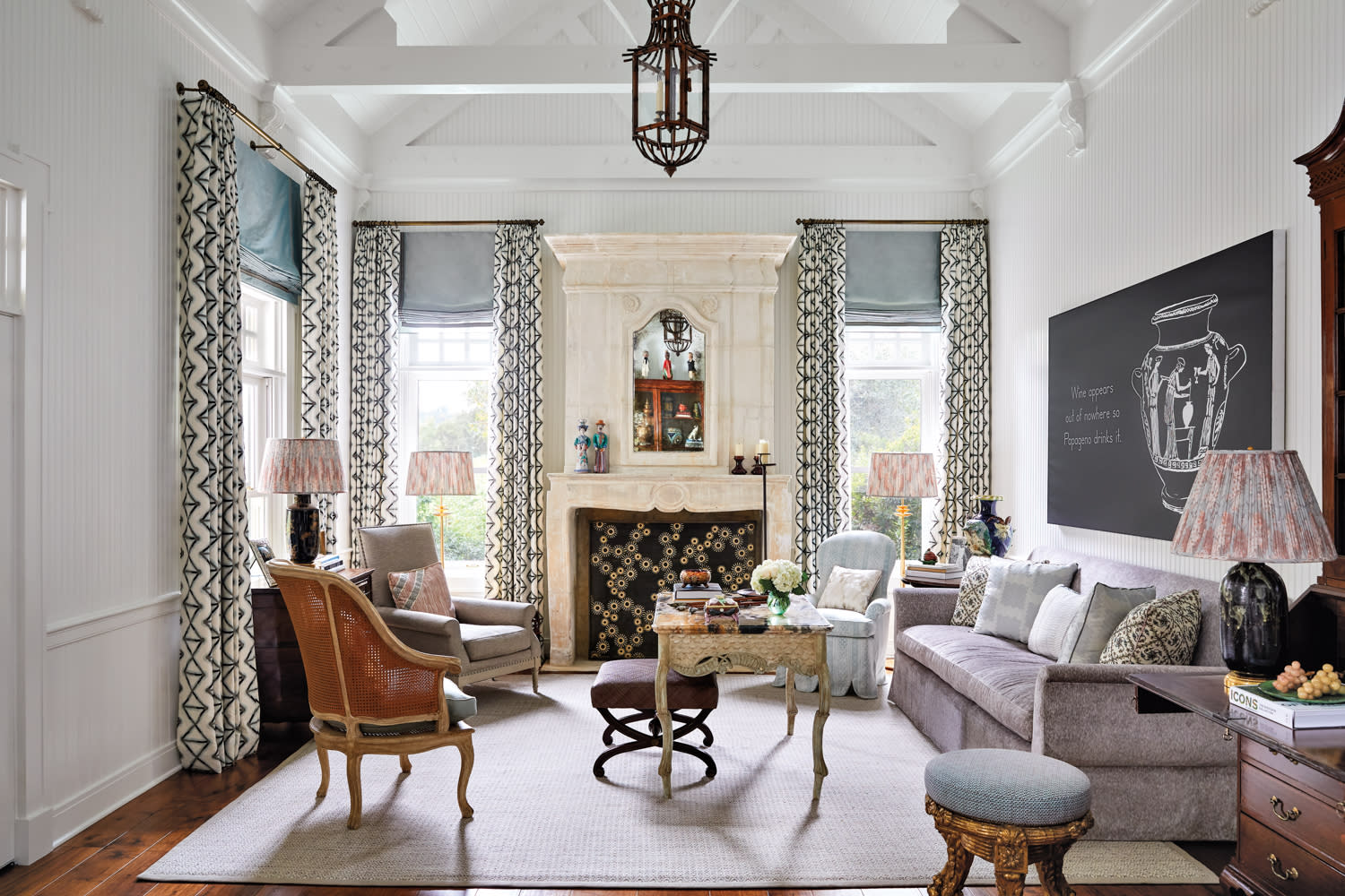 The living room has traditional and antique furniture grouped around a fireplace.