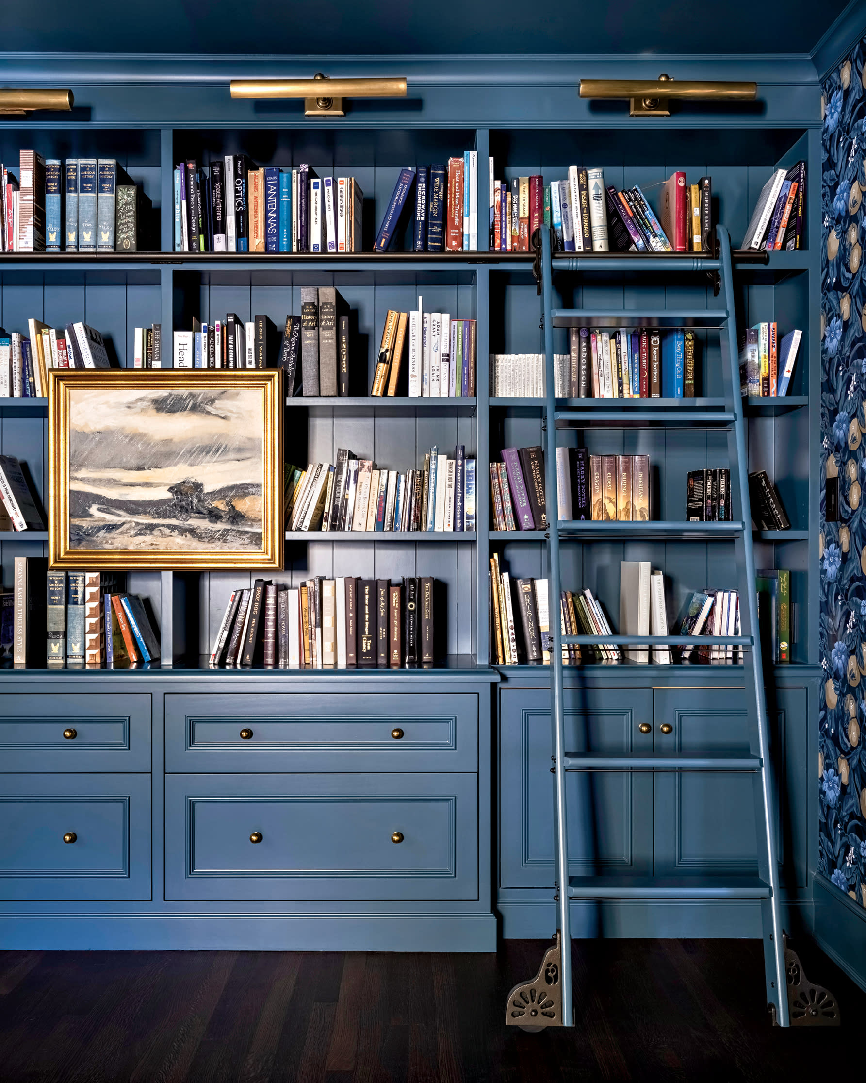 blue home library walls with a rolling ladder