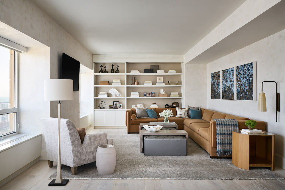 White living room with textured walls, built in shelves and Carmel colored sectional sofa.