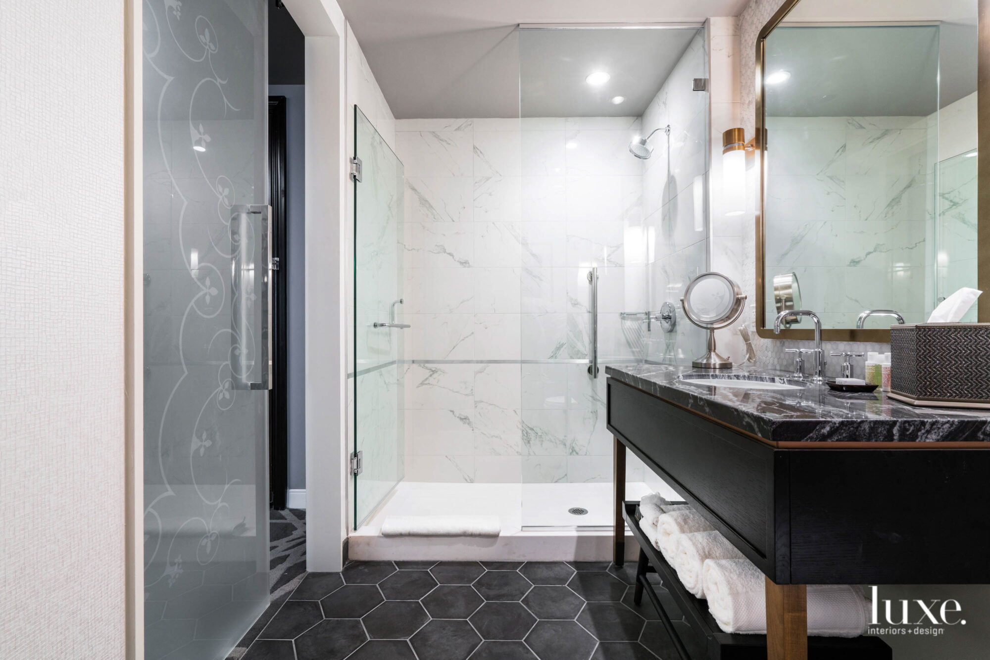 A gleaming bathroom with a marble countertop and a hexagonal tiled floor.