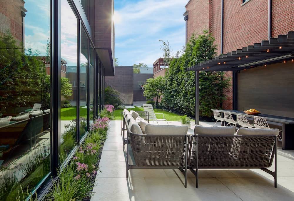 Outdoor city living room with comfortable seating and dining area.