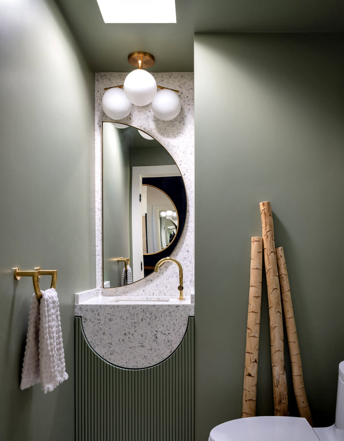 powder room with moody green walls and a terrazzo sink