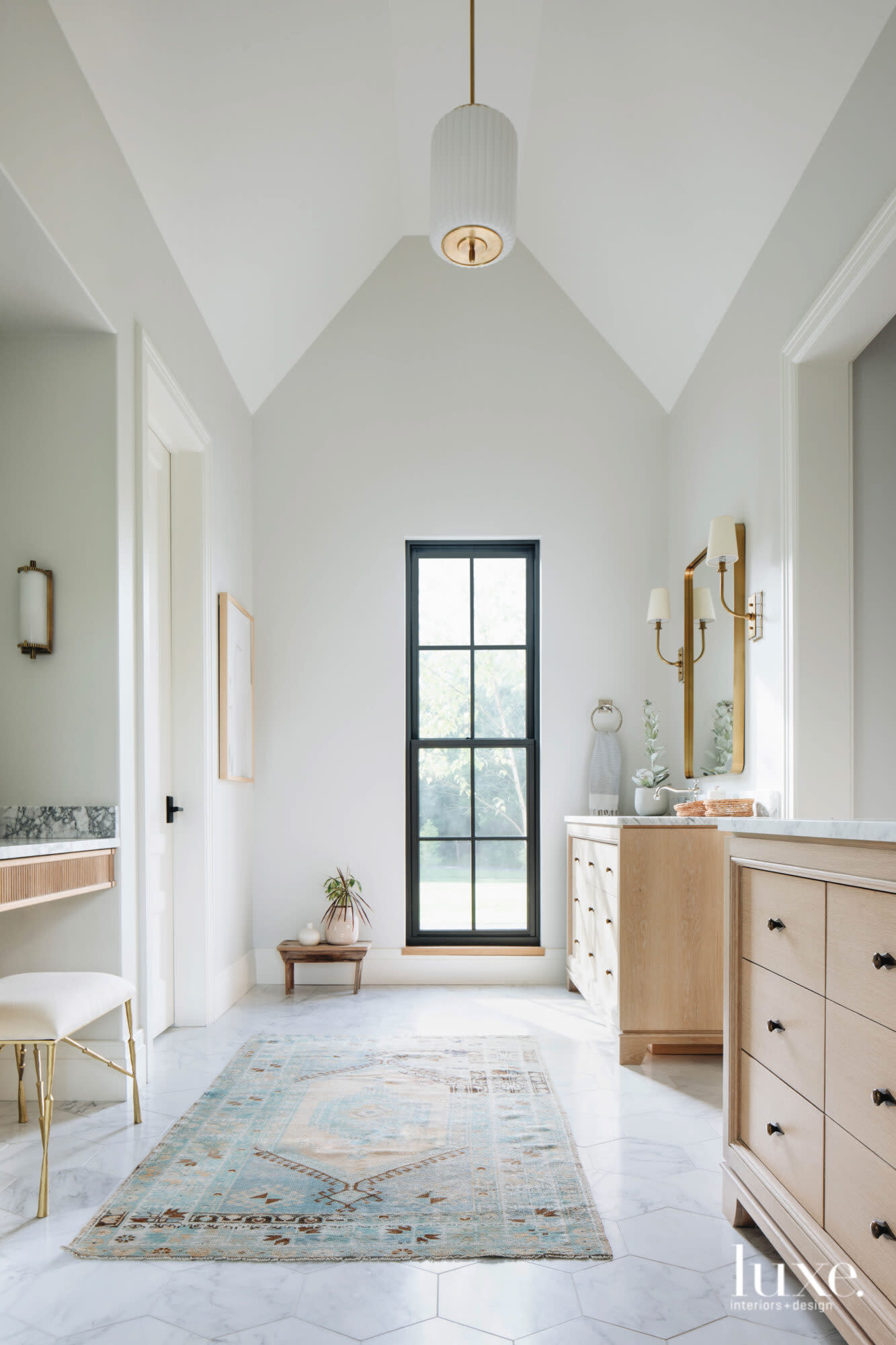 White oak vanities match perfectly with the gold finishes in this master bath.