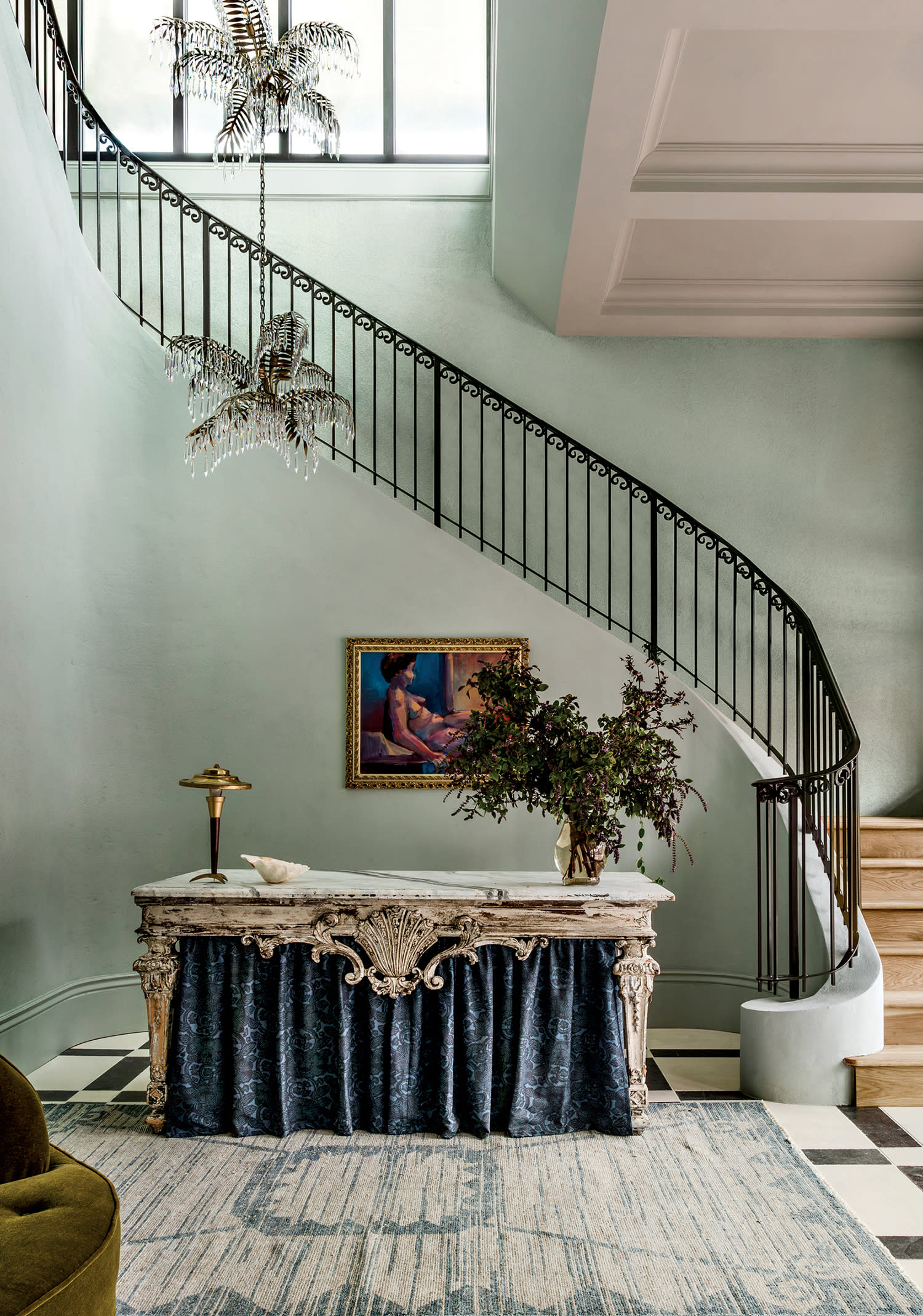a vintage-style staircase with a draped console table in Hotel Perle’s elegant lobby