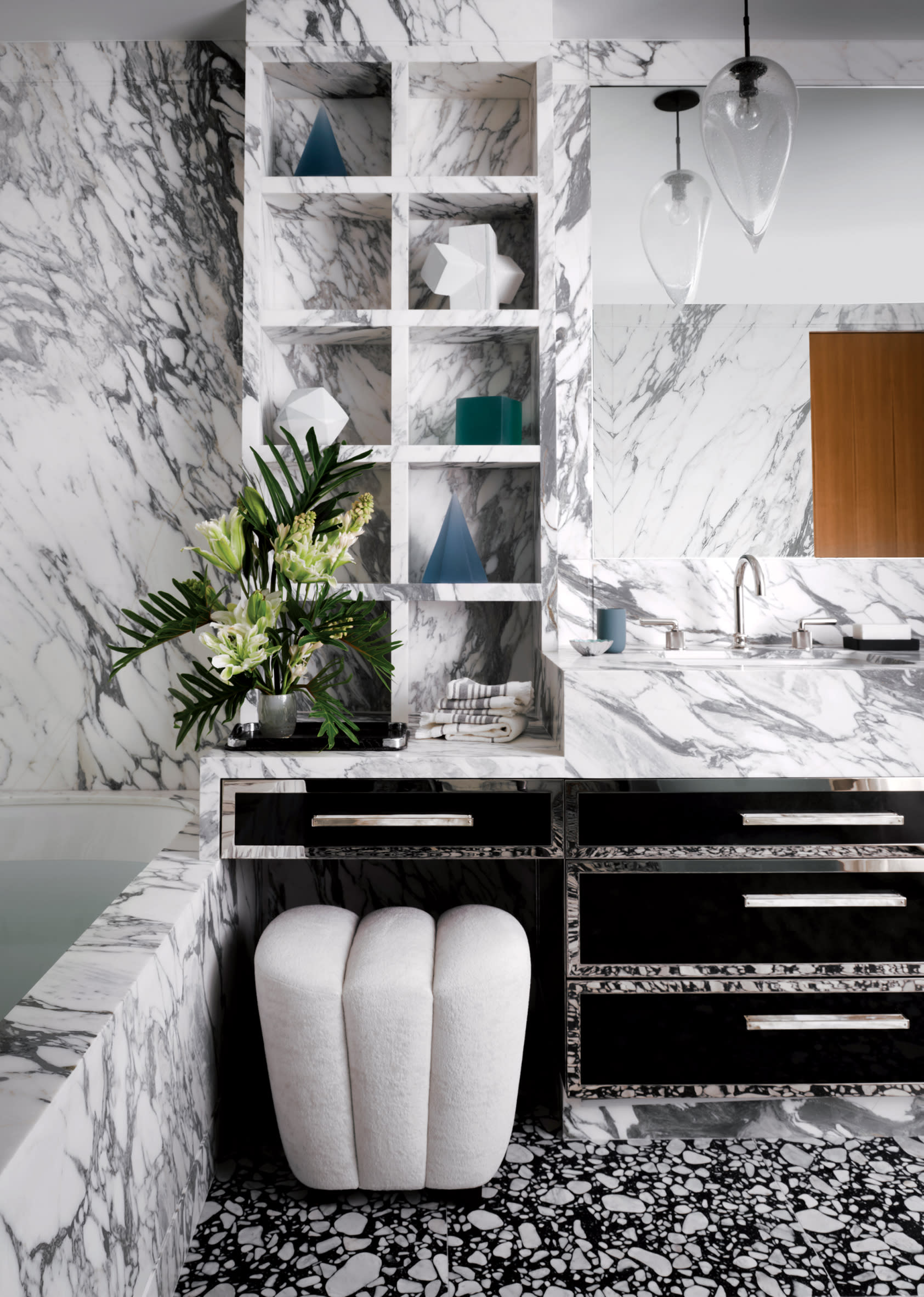 immersive bathroom with black and white marble across the walls, floors and tub